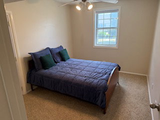 Second bedroom upstairs with great lighting and a good-sized closet and a ceiling fan with integrated lighting, neutral wall paint, and a double-pane window