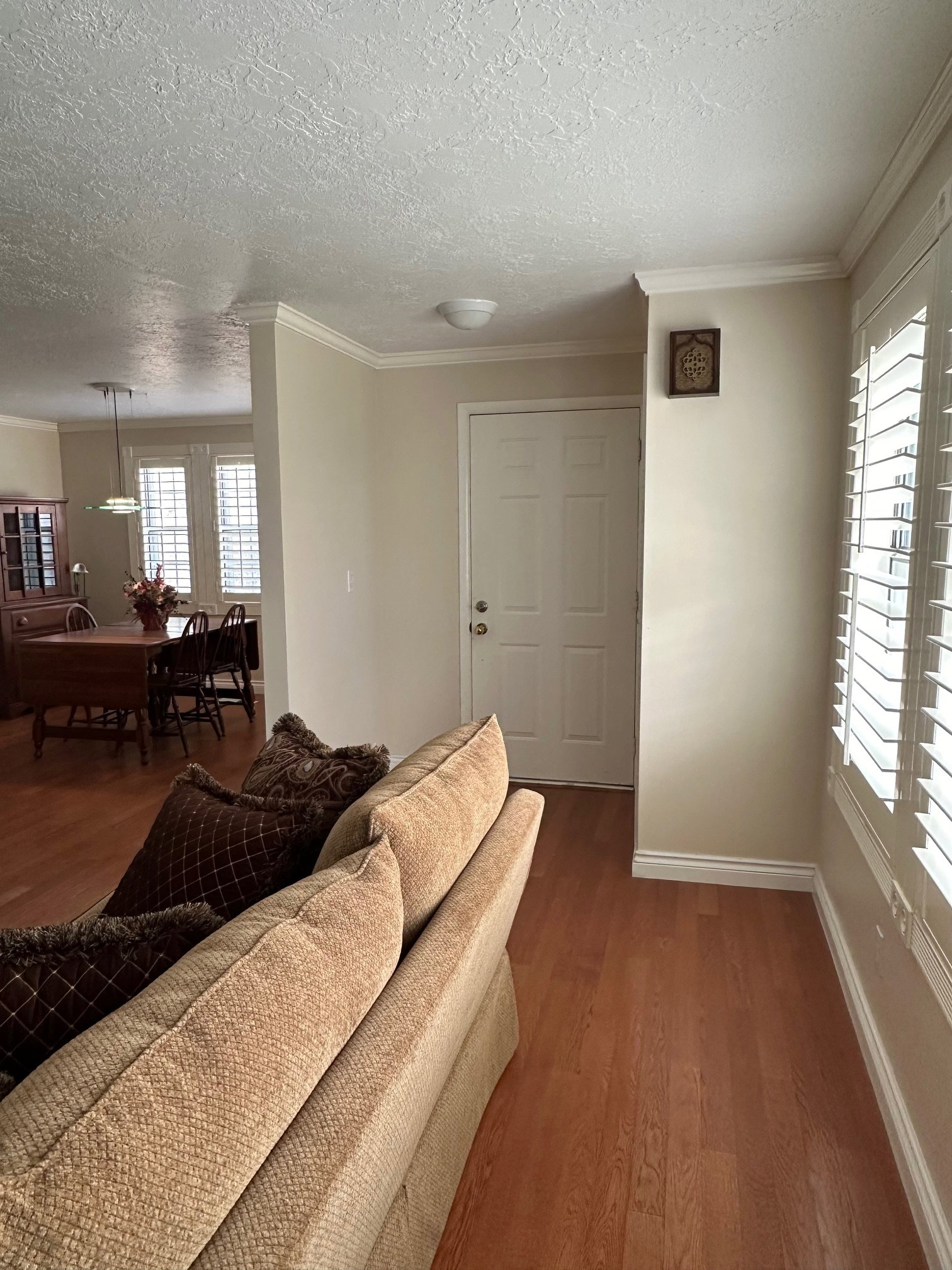 Entryway featuring with entry closet to the right, crown molding, and wood flooring