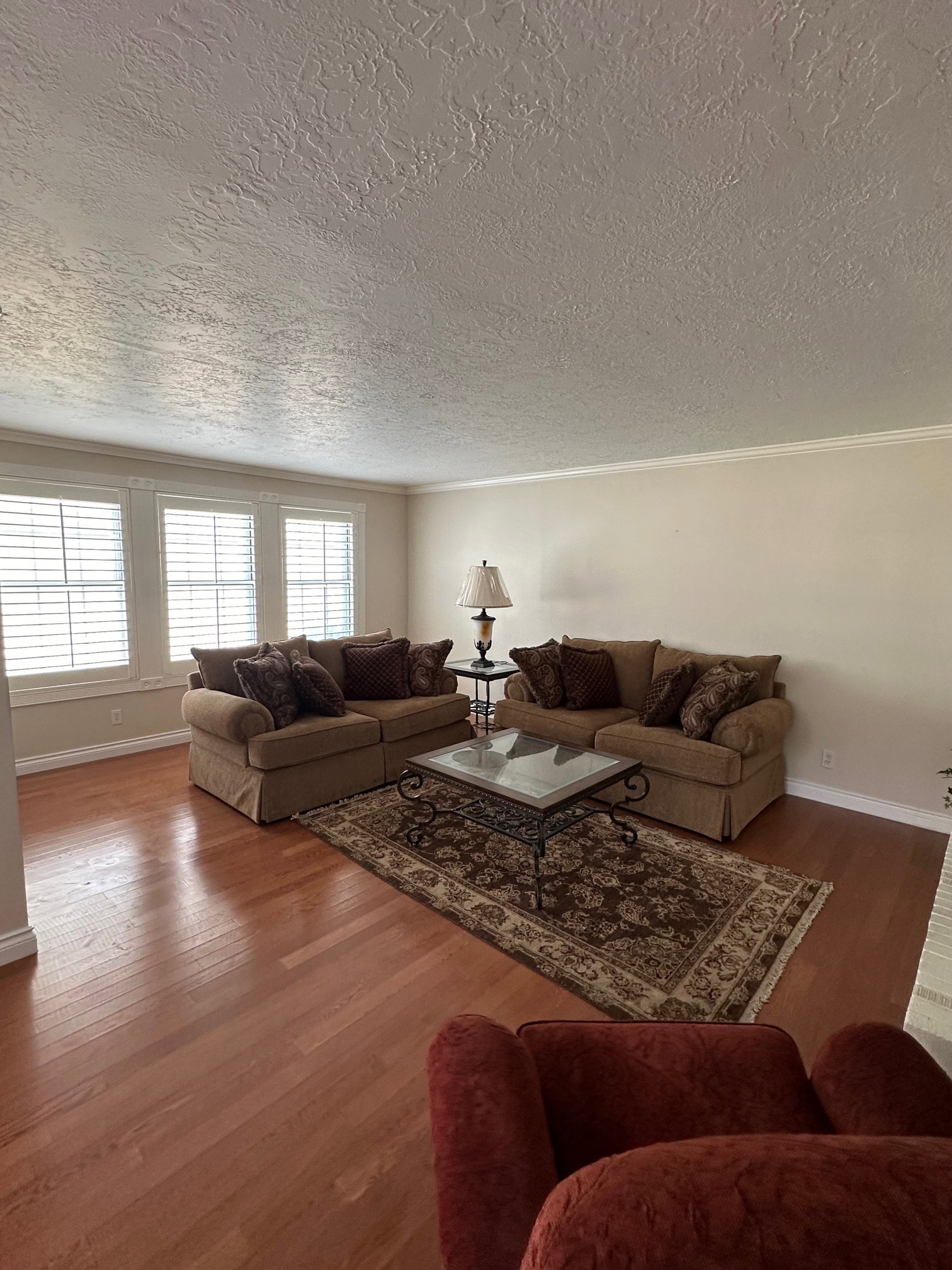 Hardwood flooring, multiple windows with plantation shutters, crown molding. Light and bright.