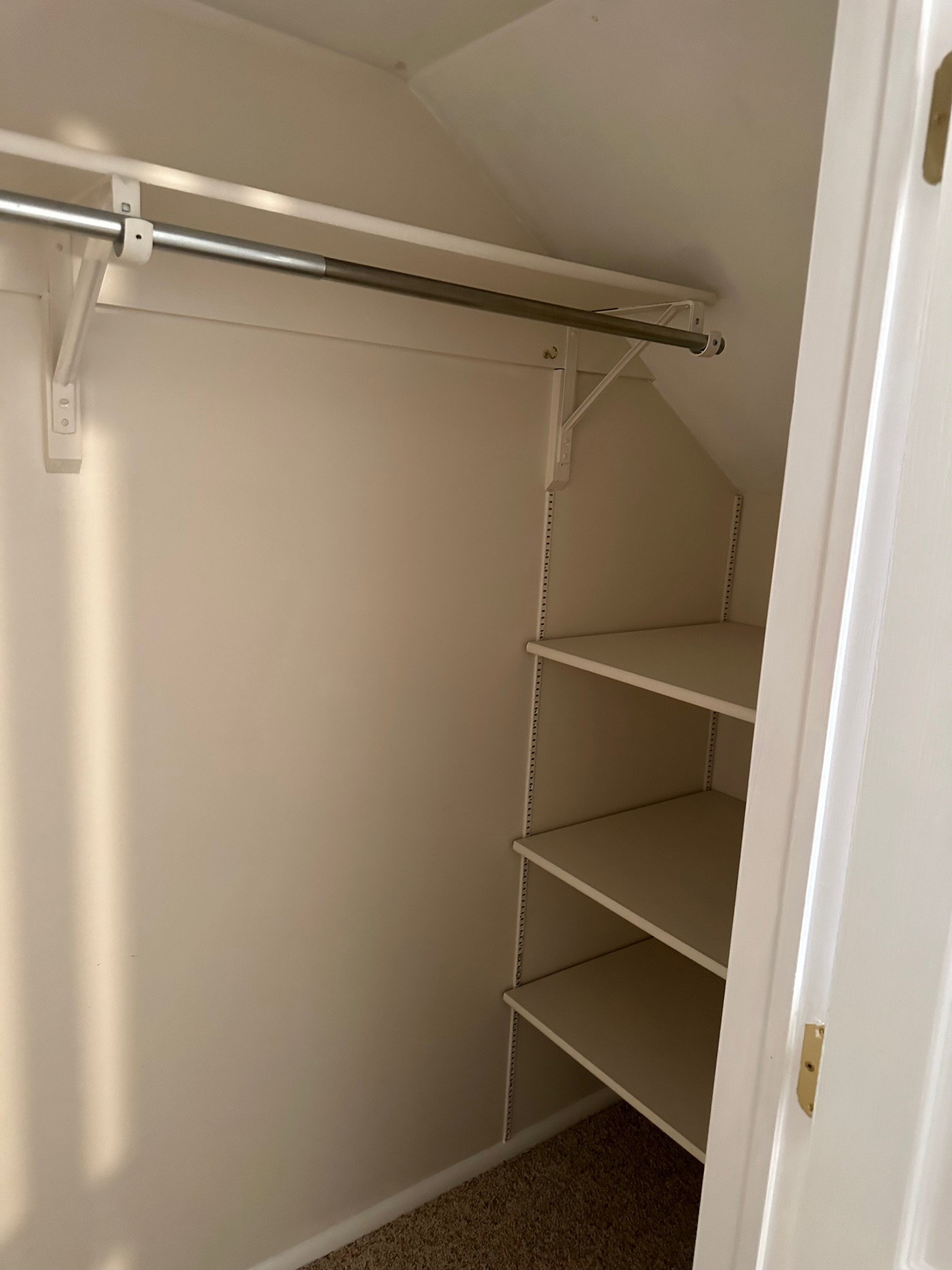 Built-in closet shelving and hanging rod provide storage in second bedroom closet.