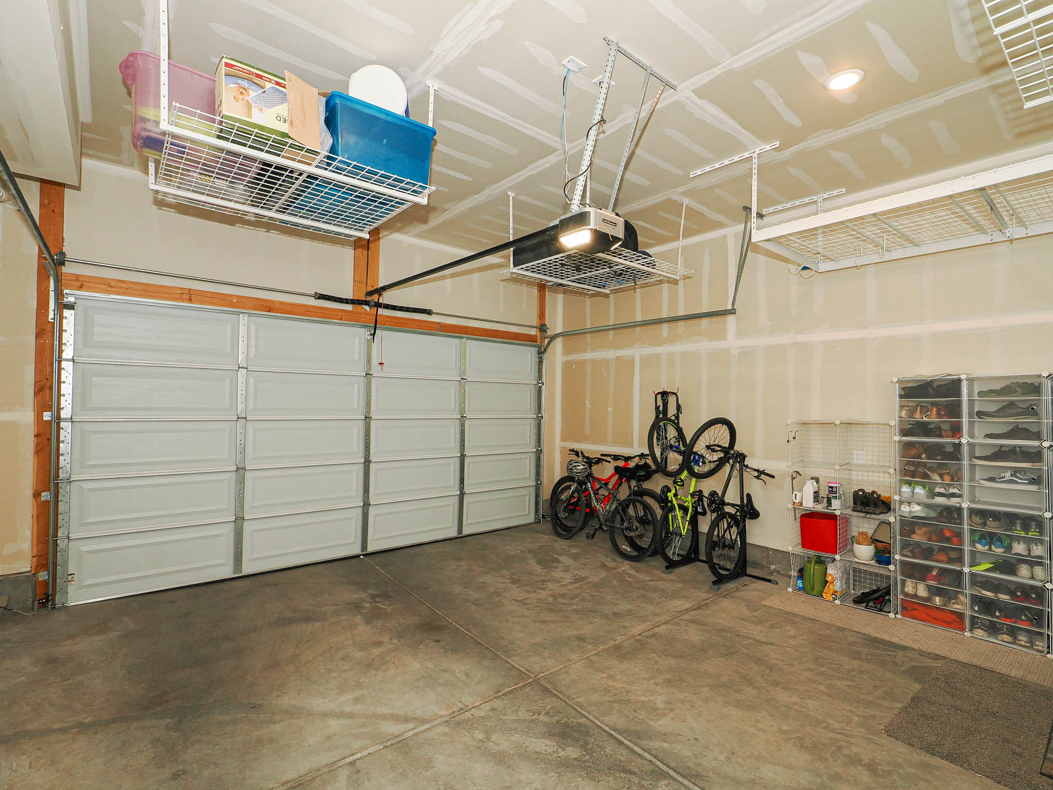 Spacious garage featuring a concrete floor, two paneled garage doors, and overhead storage racks