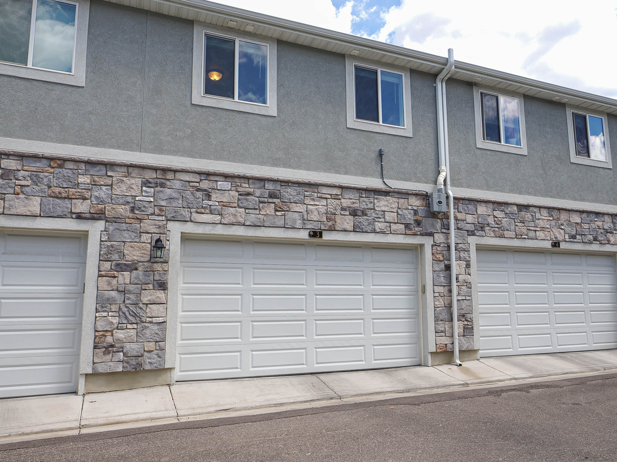 Exterior showcasing a multi-level structure with a combination of stucco and stone veneer siding
