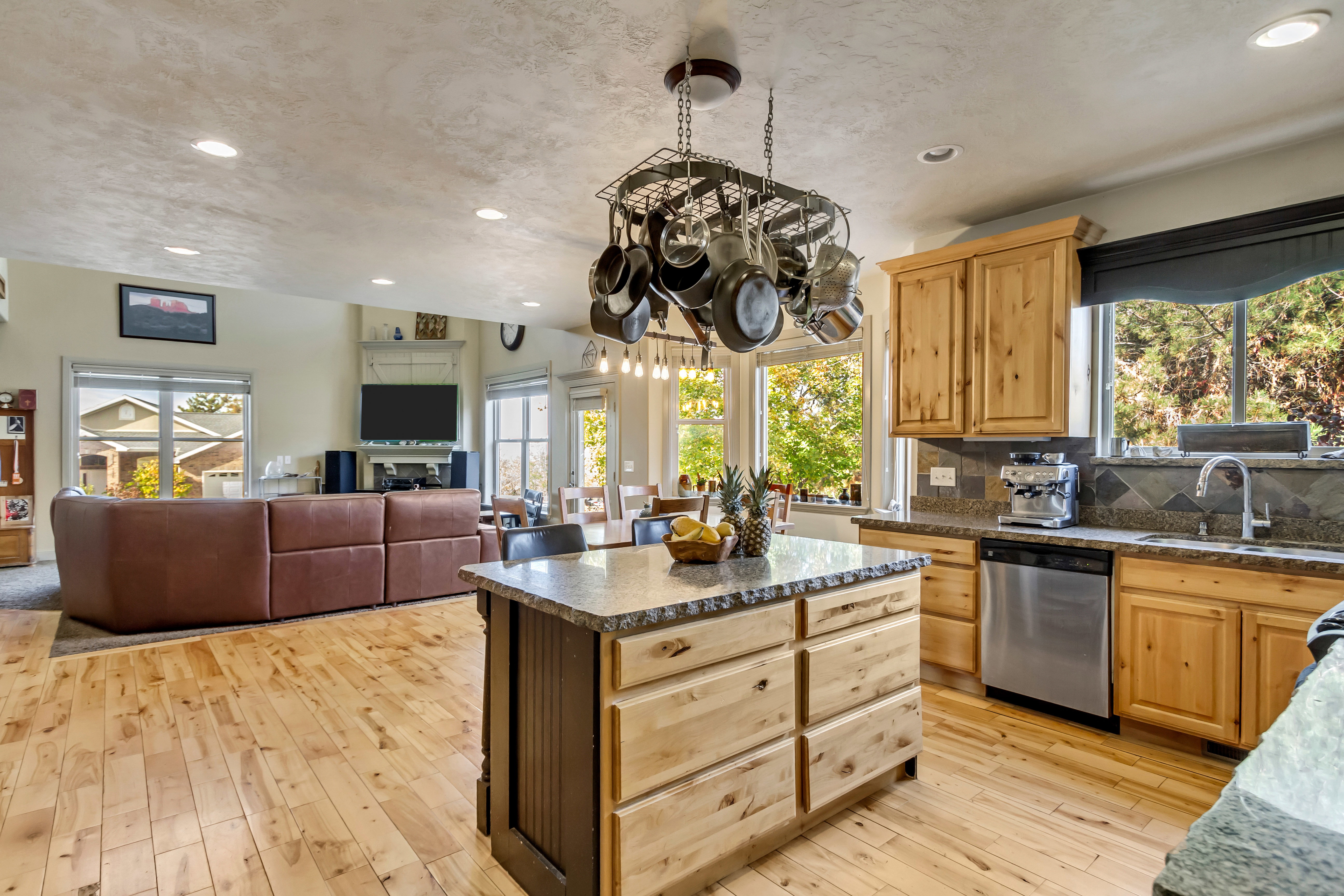 Open-concept living space featuring light wood-finish flooring, recessed lighting, and large windows
