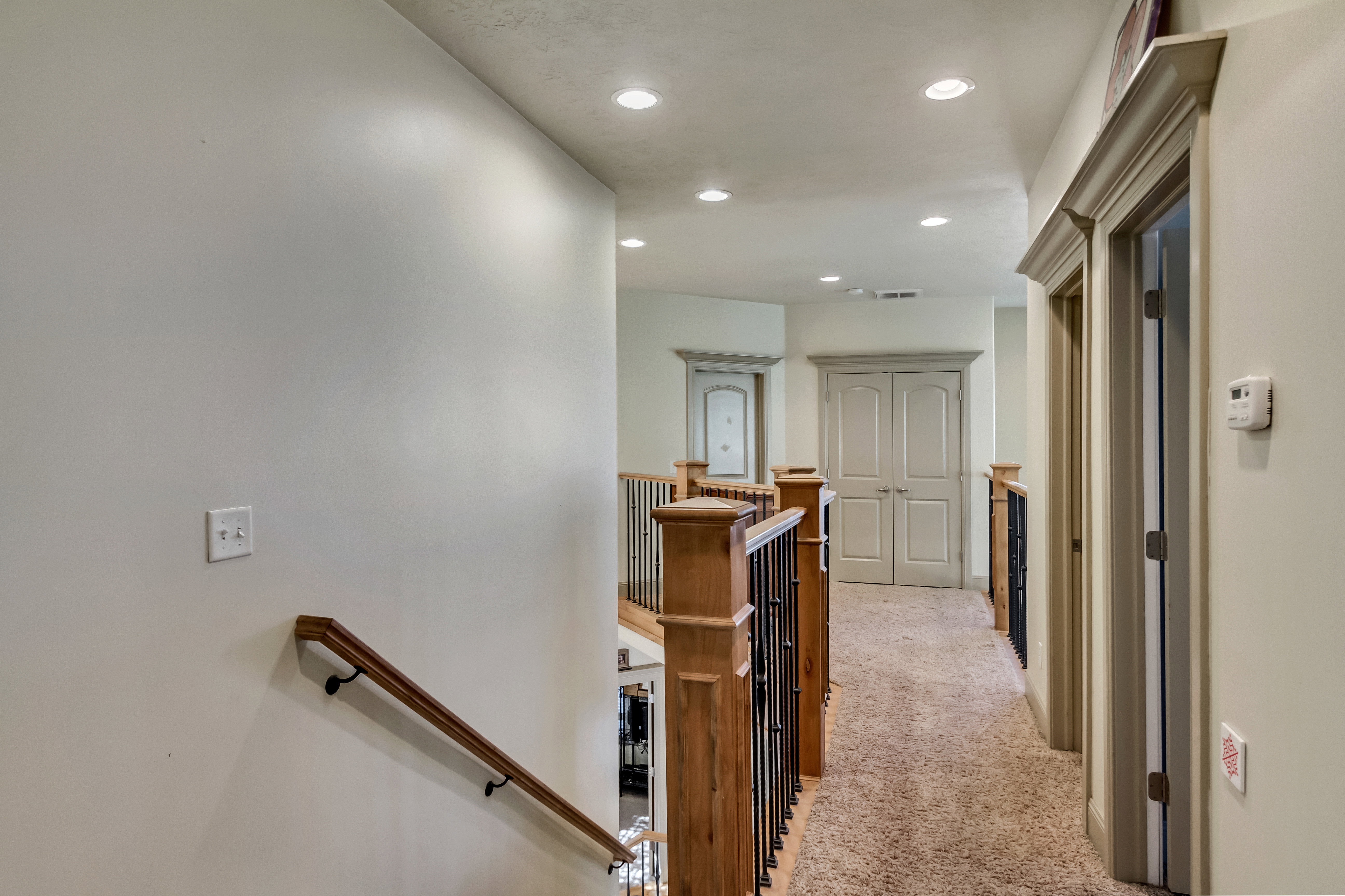 Upper-level hallway featuring recessed lighting and carpet flooring