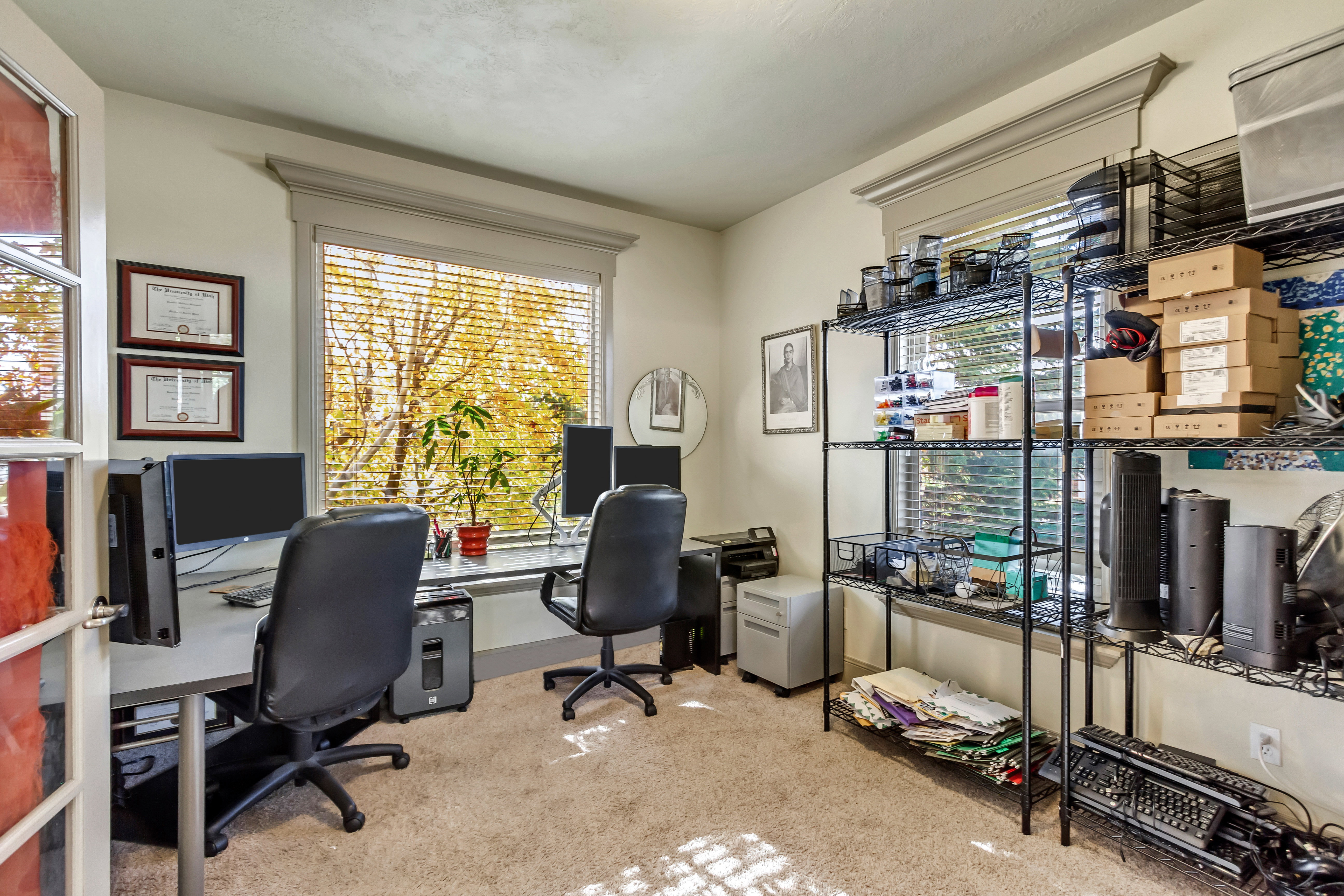 Carpeted room featuring a large window with horizontal blinds, providing ample natural light