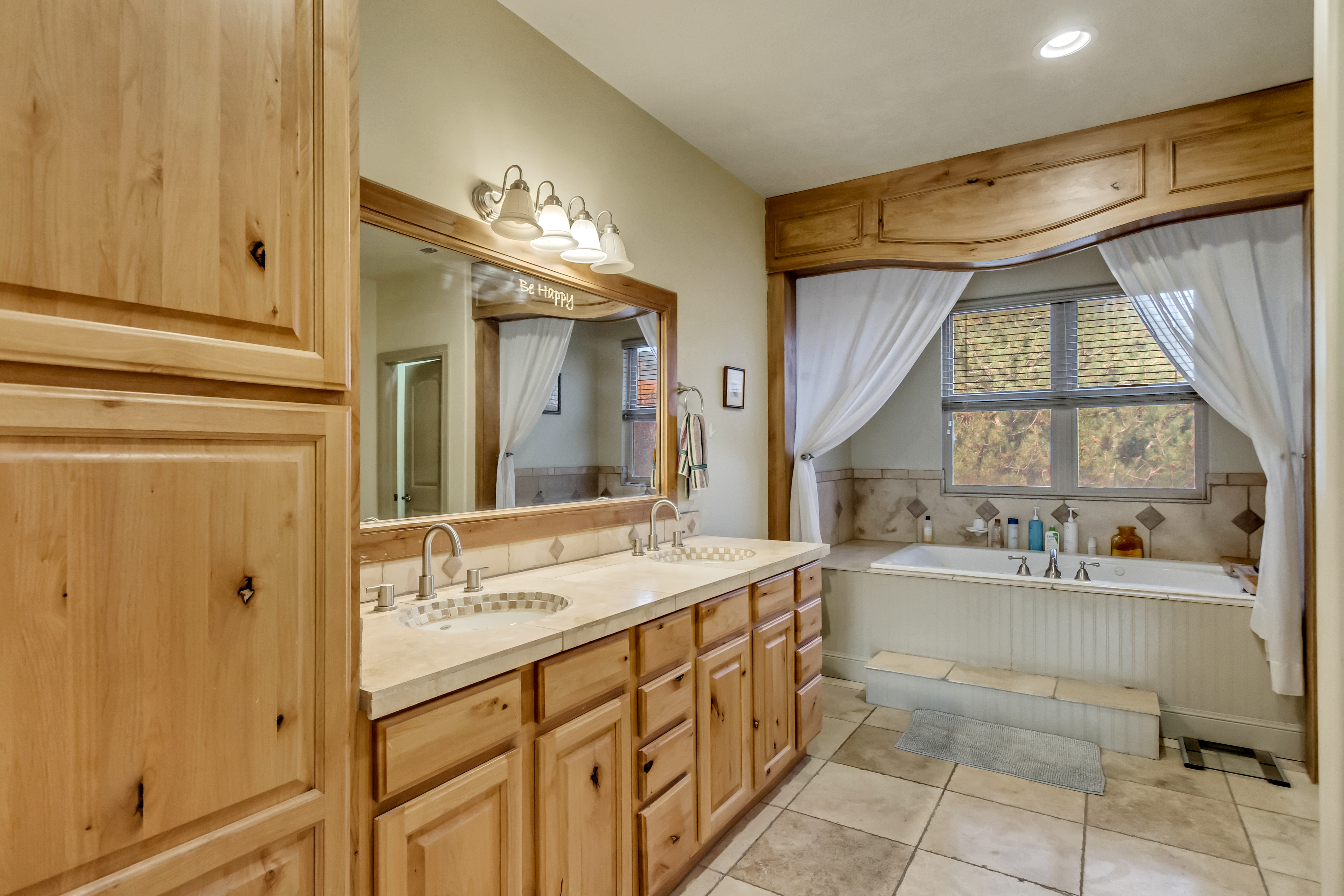Bathroom featuring a dual vanity with light-toned countertops and undermount sinks