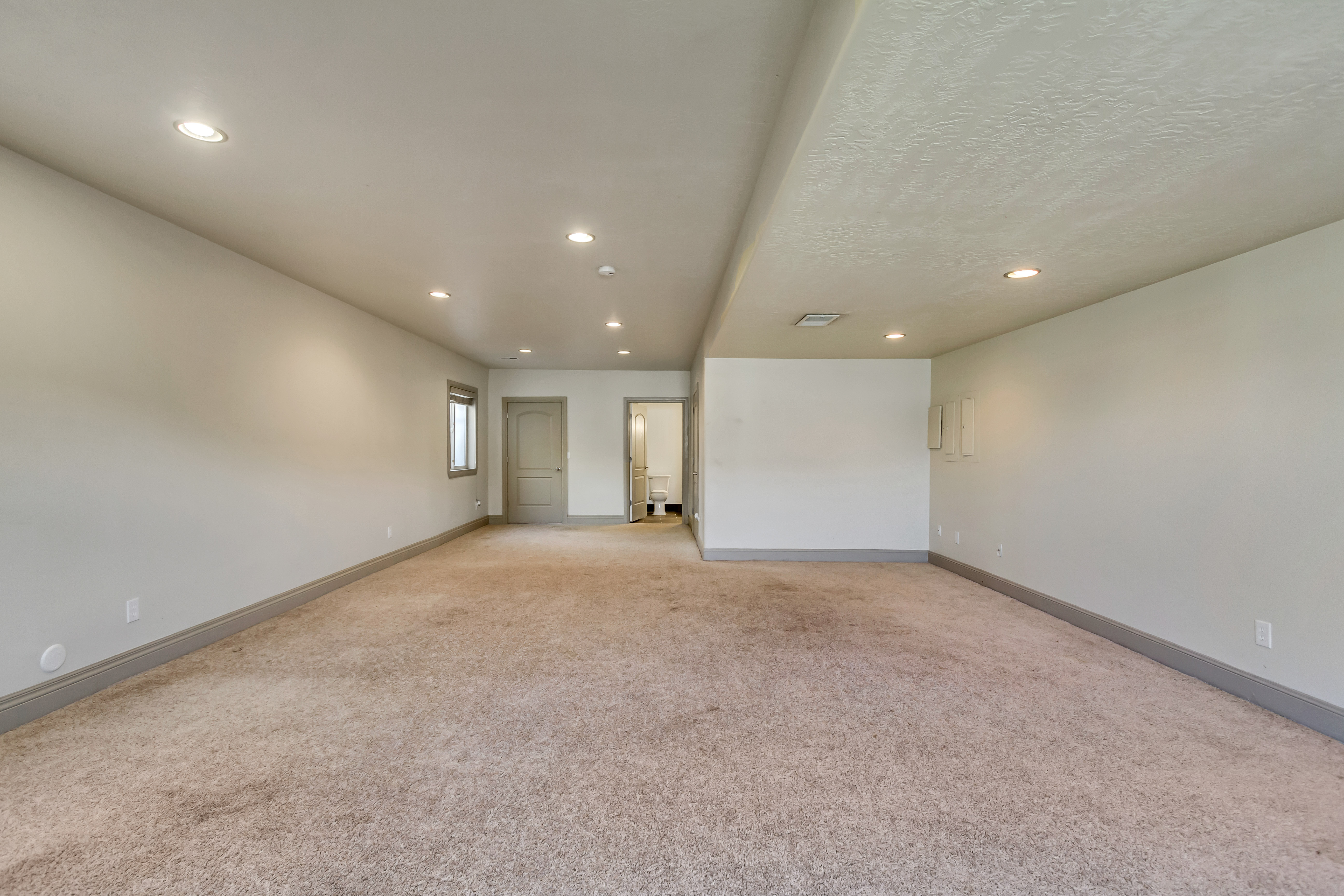 Spacious room featuring neutral carpeting and light-colored walls