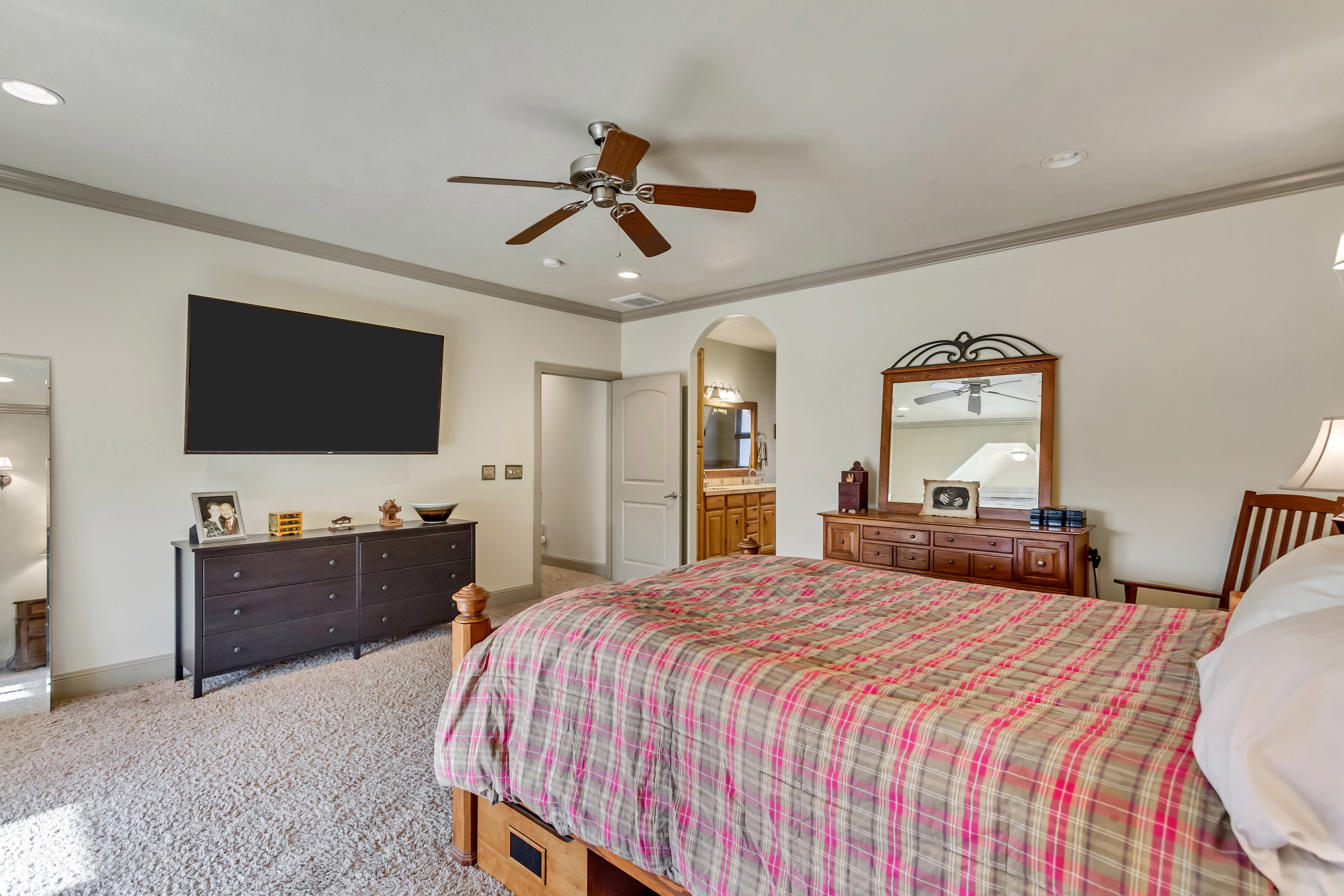 Spacious room with plush carpeting and a ceiling fan