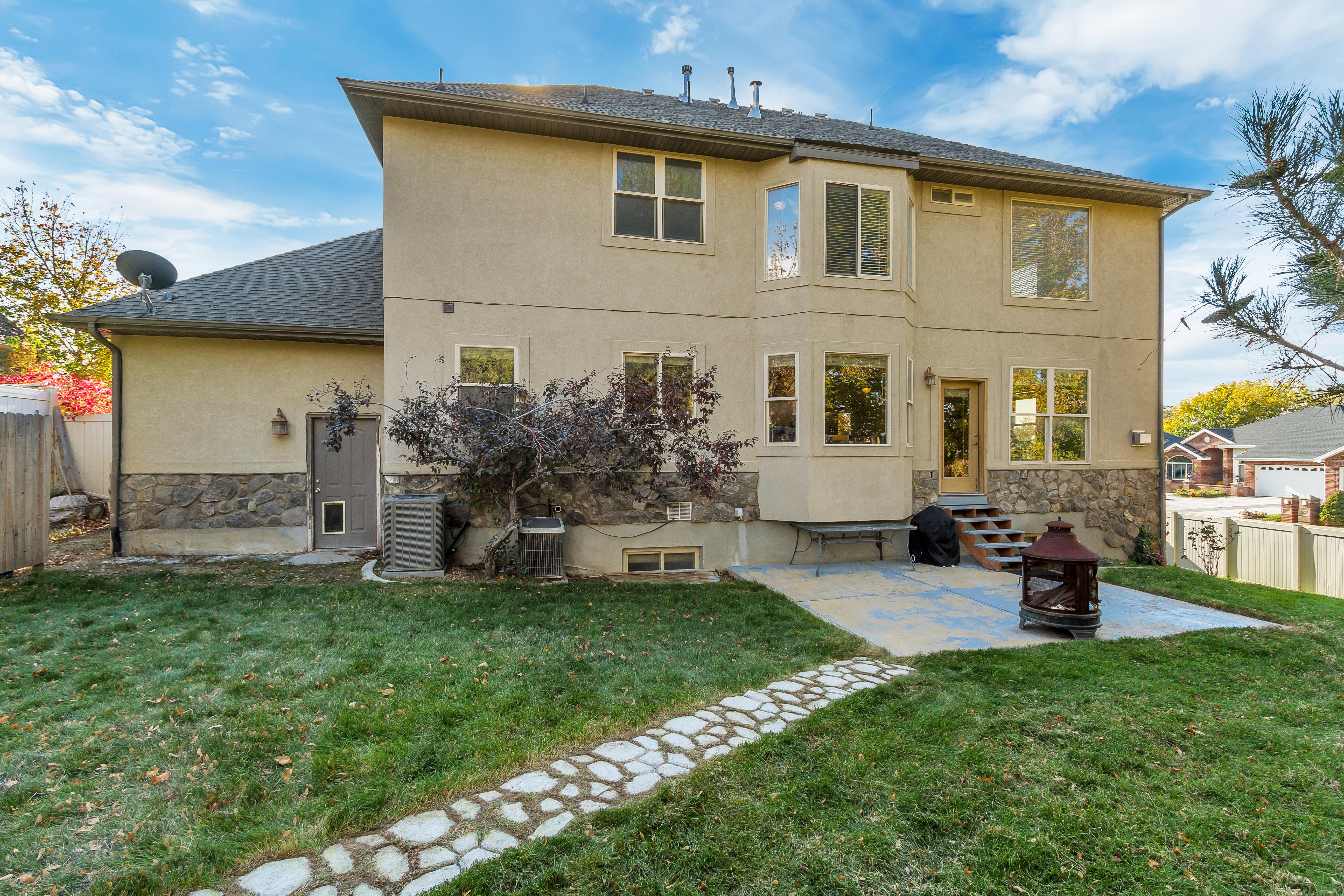 Rear stucco exterior with stone accents and multiple large windows