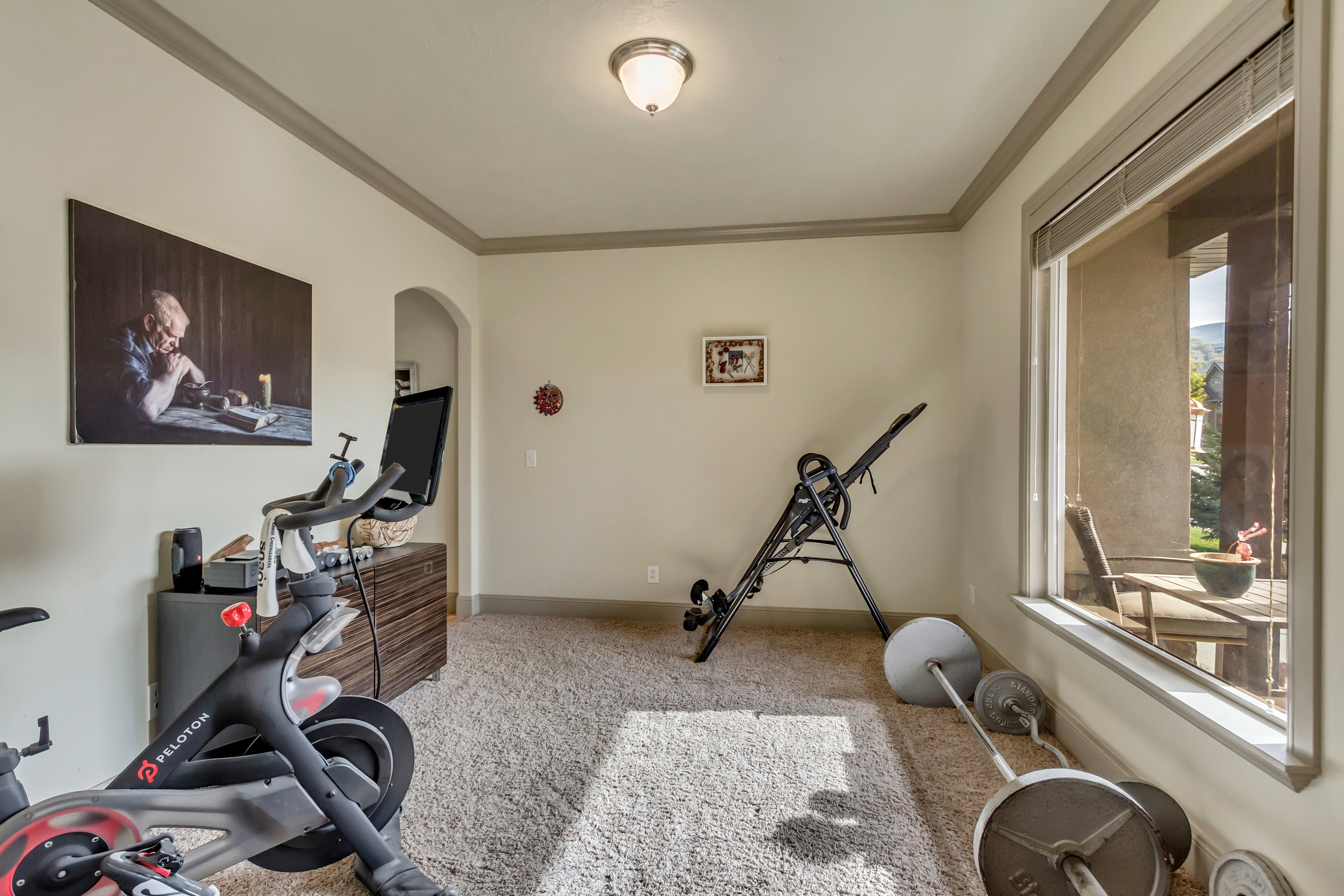 Carpeted room with a wide window overlooking an exterior patio