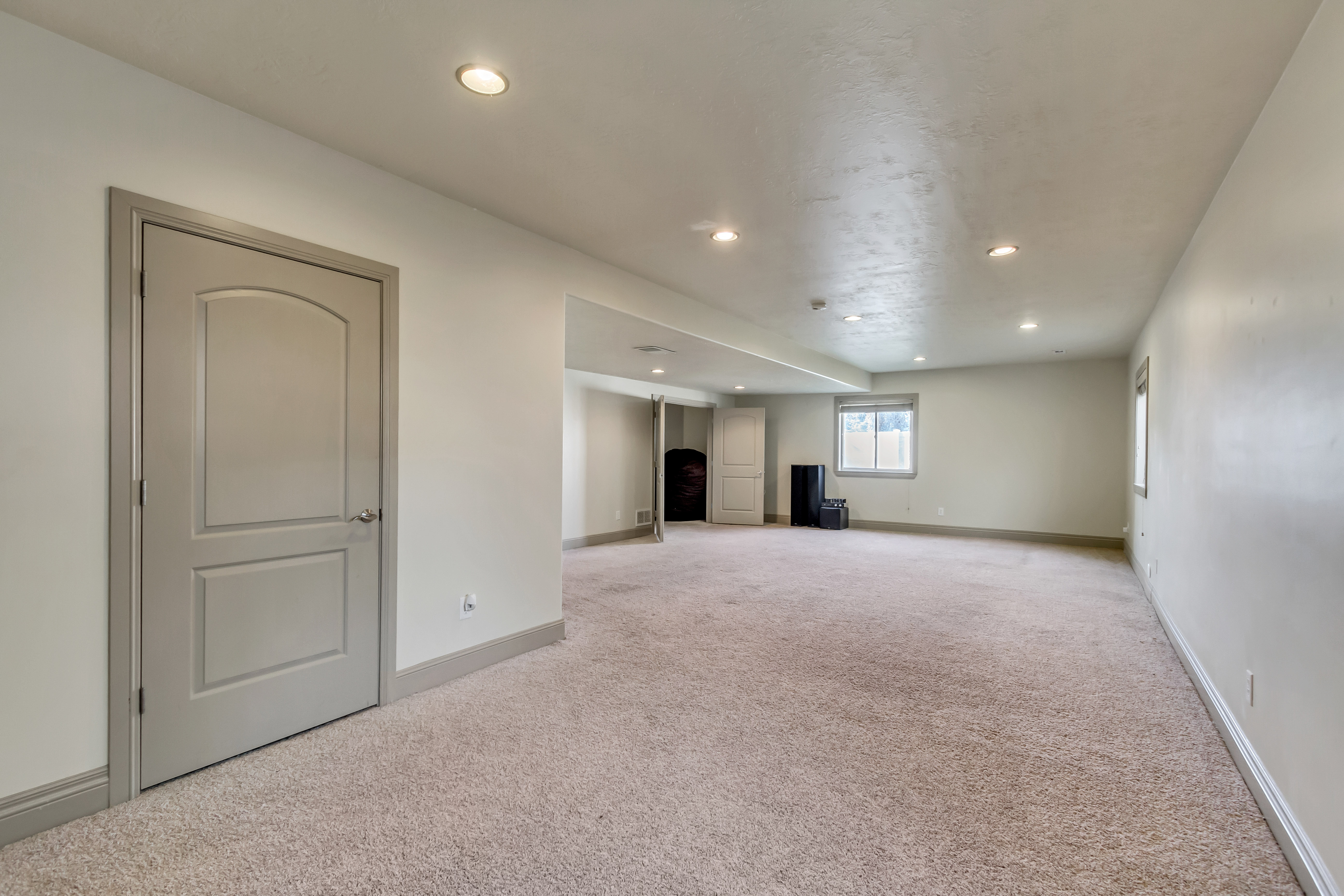Spacious room featuring neutral carpeting, recessed ceiling lighting, and multiple windows