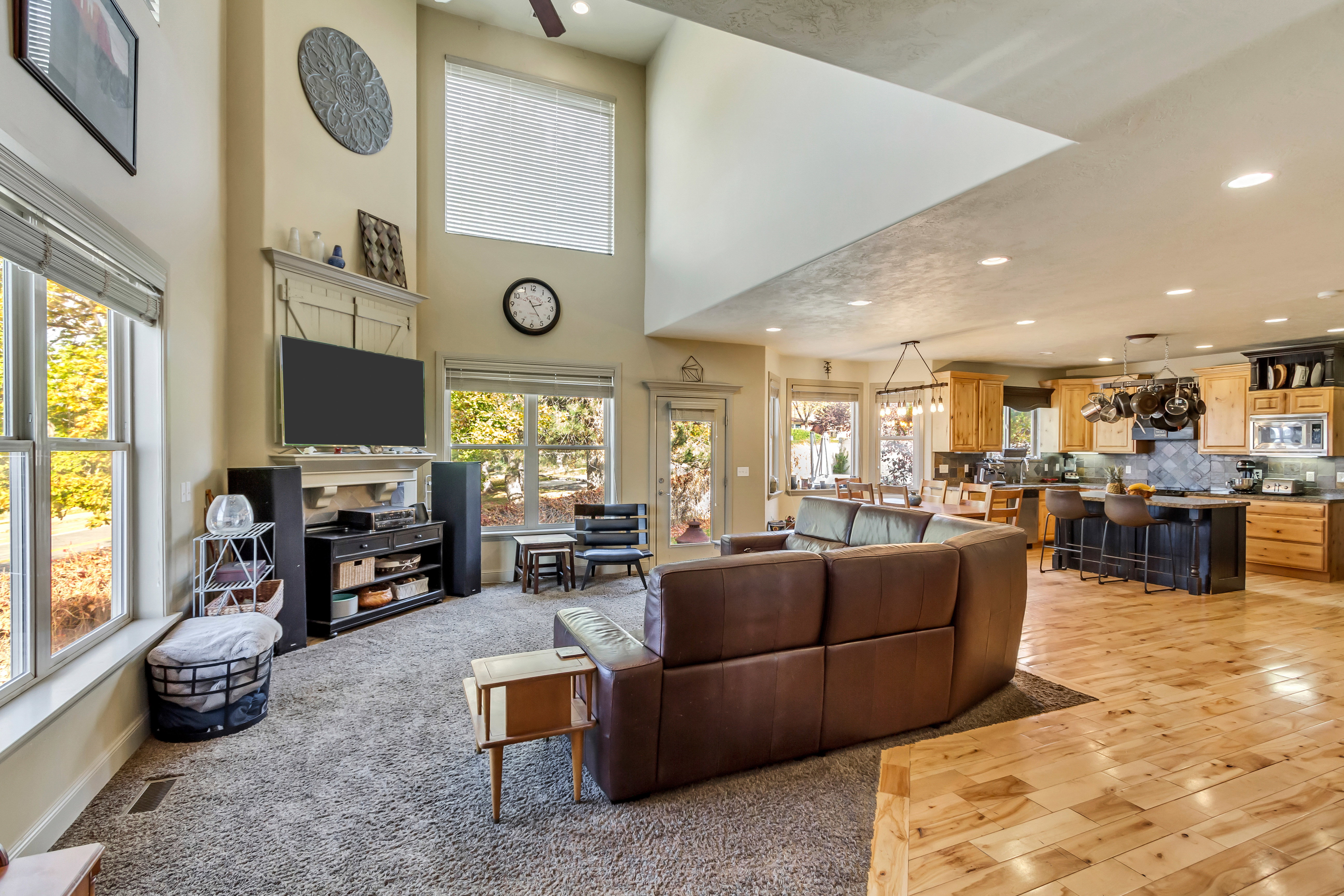 Spacious open-concept living area featuring high ceilings and abundant natural light from multiple large windows