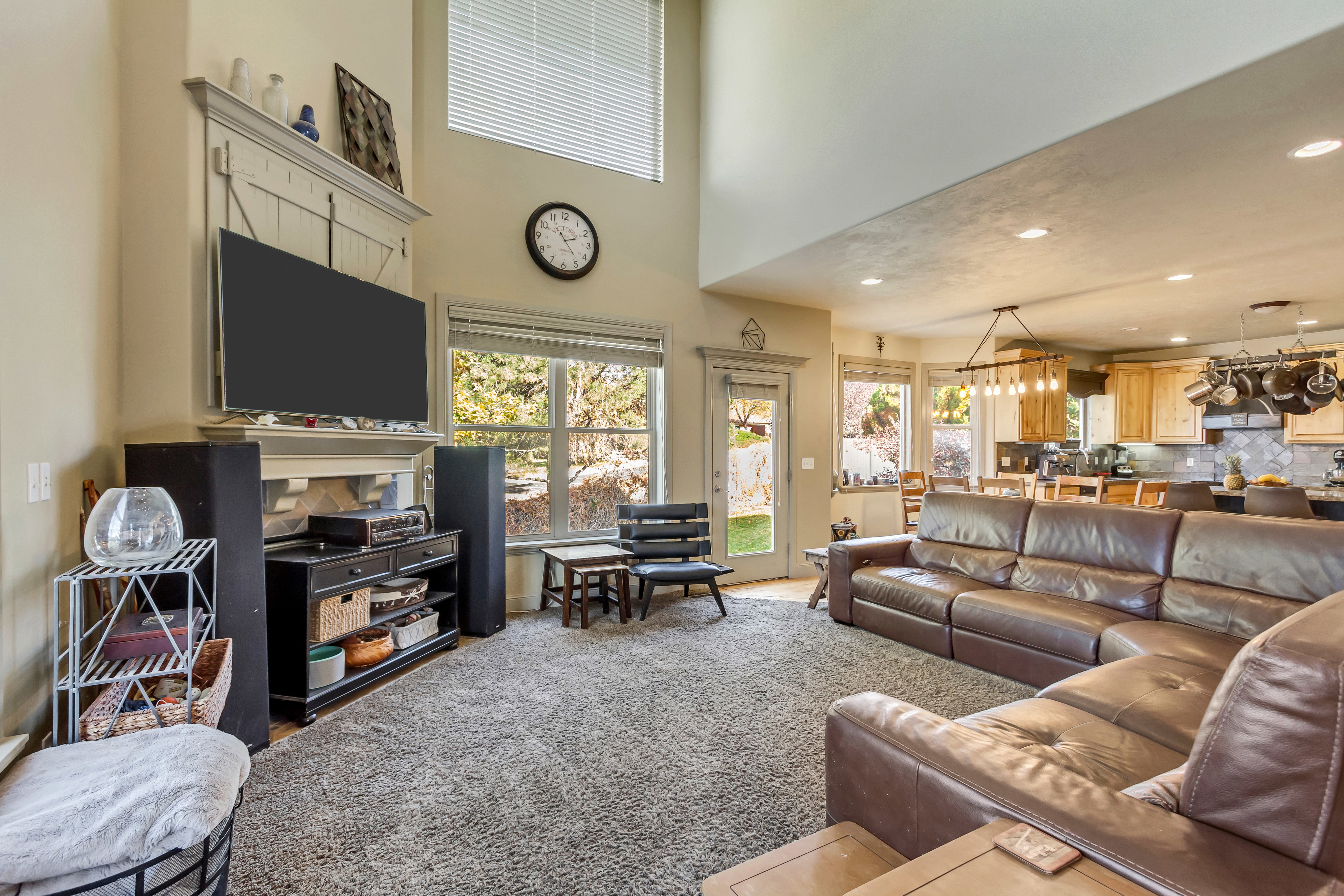 Living area featuring a two-story ceiling, a fireplace with a decorative mantel, and abundant natural light from multiple windows