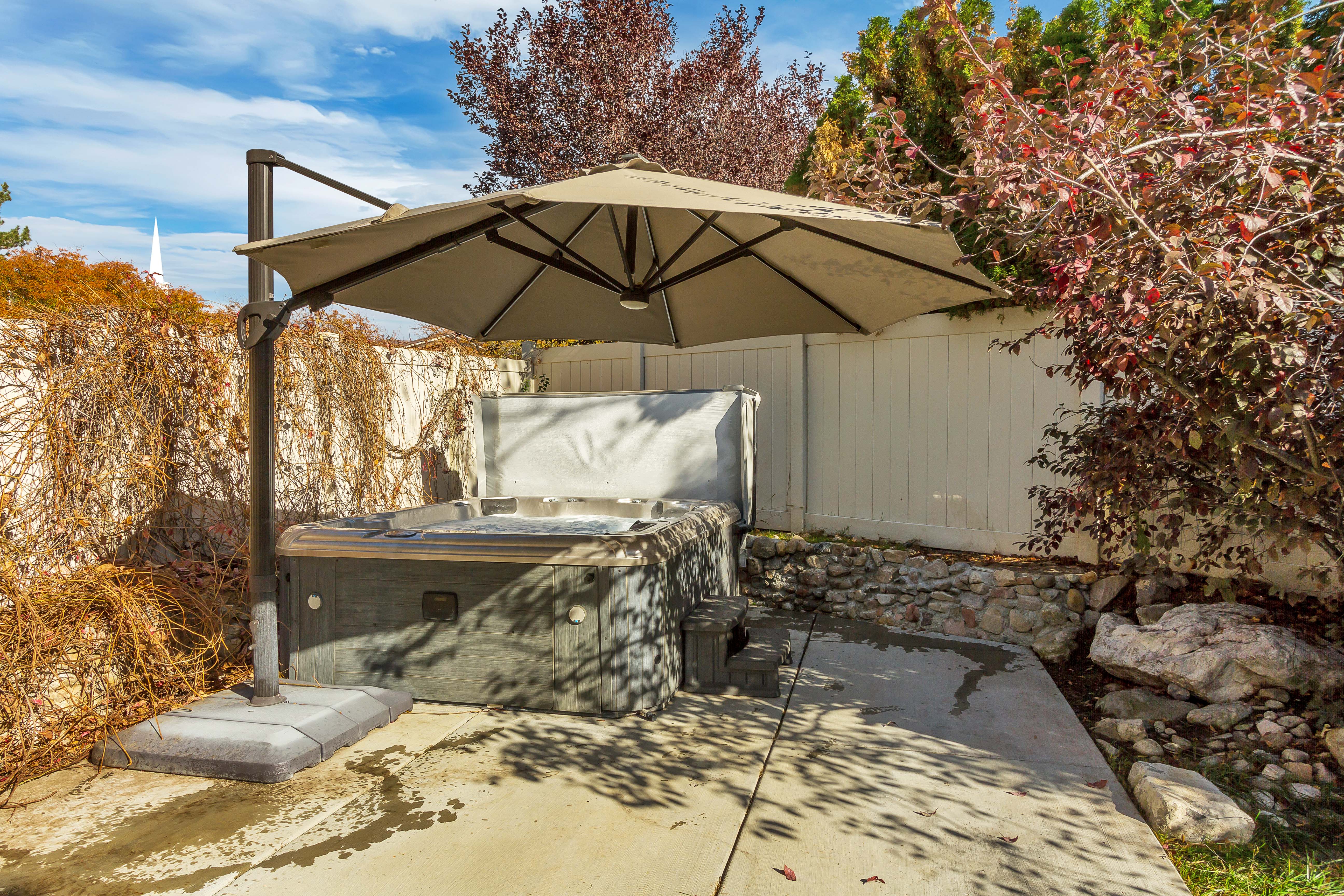 Outdoor spa with accompanying steps and an adjustable cantilever umbrella