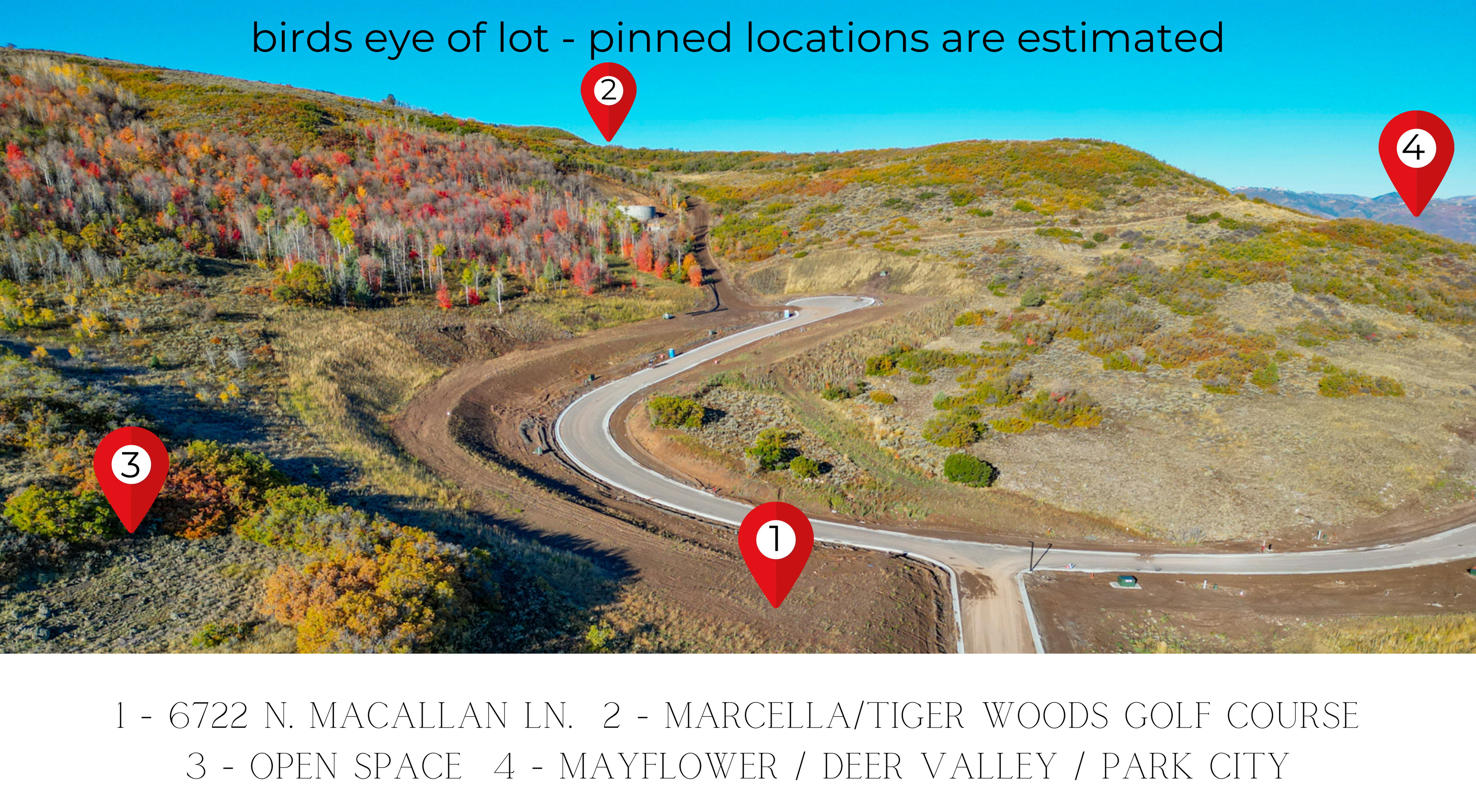 Expansive hillside lot featuring a paved road, natural terrain, and distant mountain ranges