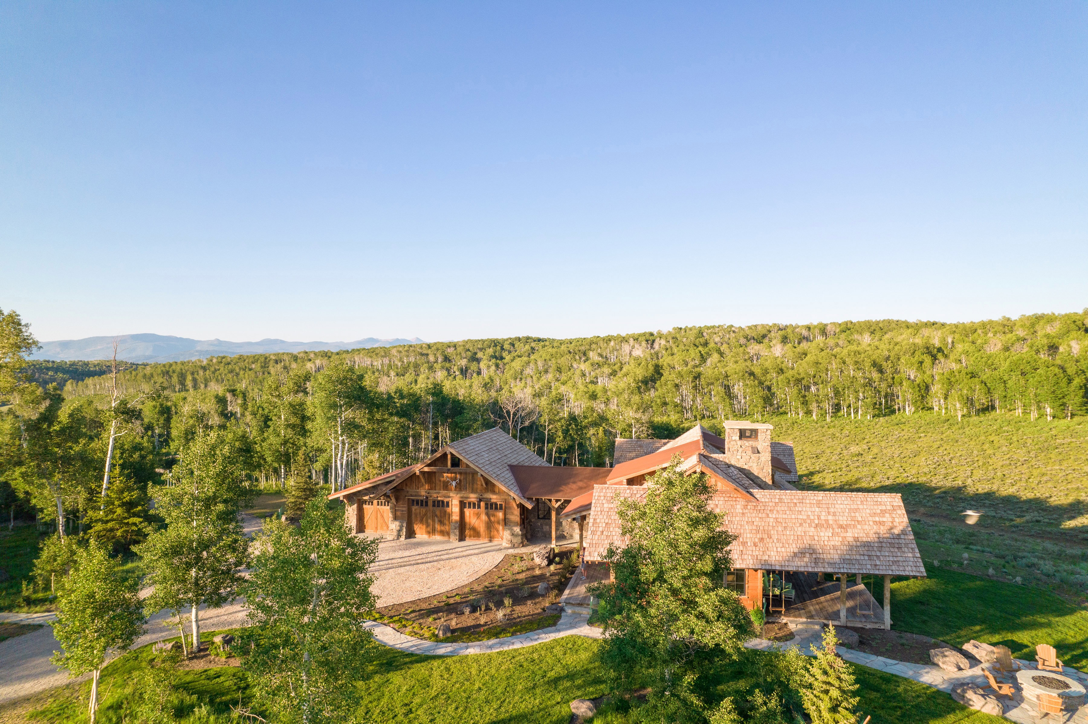 Rustic-style architecture featuring a multi-gabled roofline and stone chimney