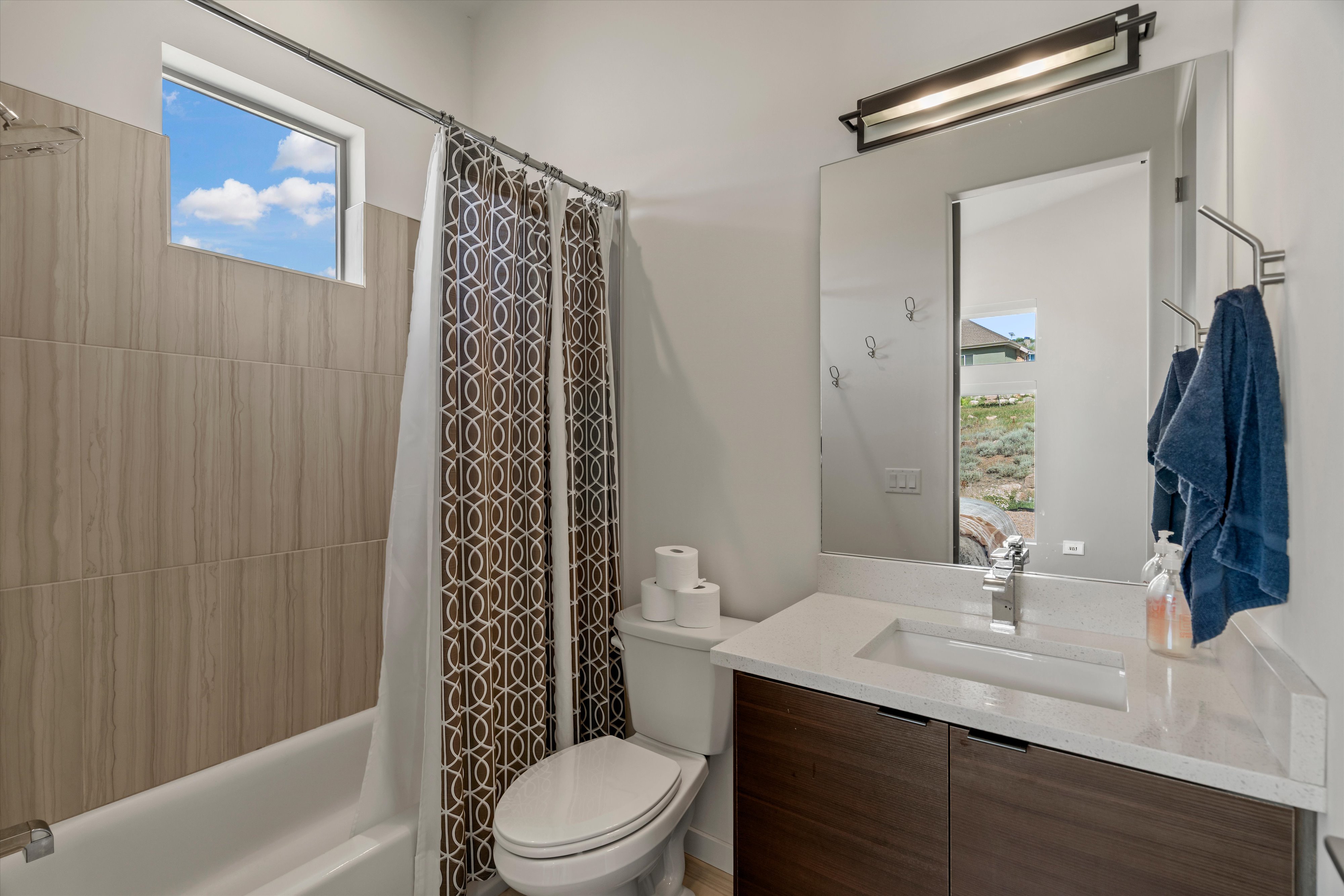 Bathroom vanity featuring a light-toned countertop with an integrated rectangular sink