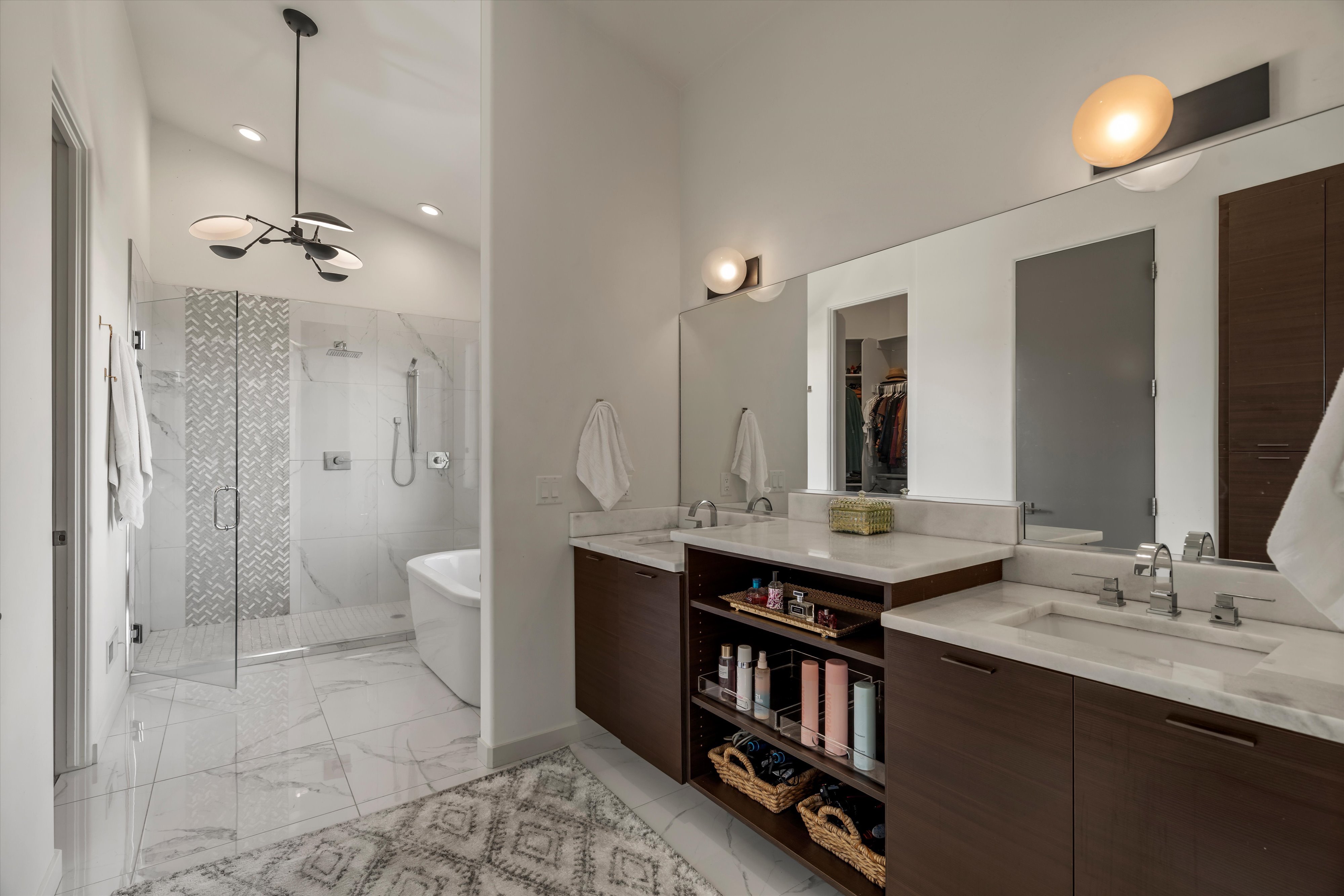 Dual vanity featuring wood-finish cabinetry, white countertops, and undermount sinks