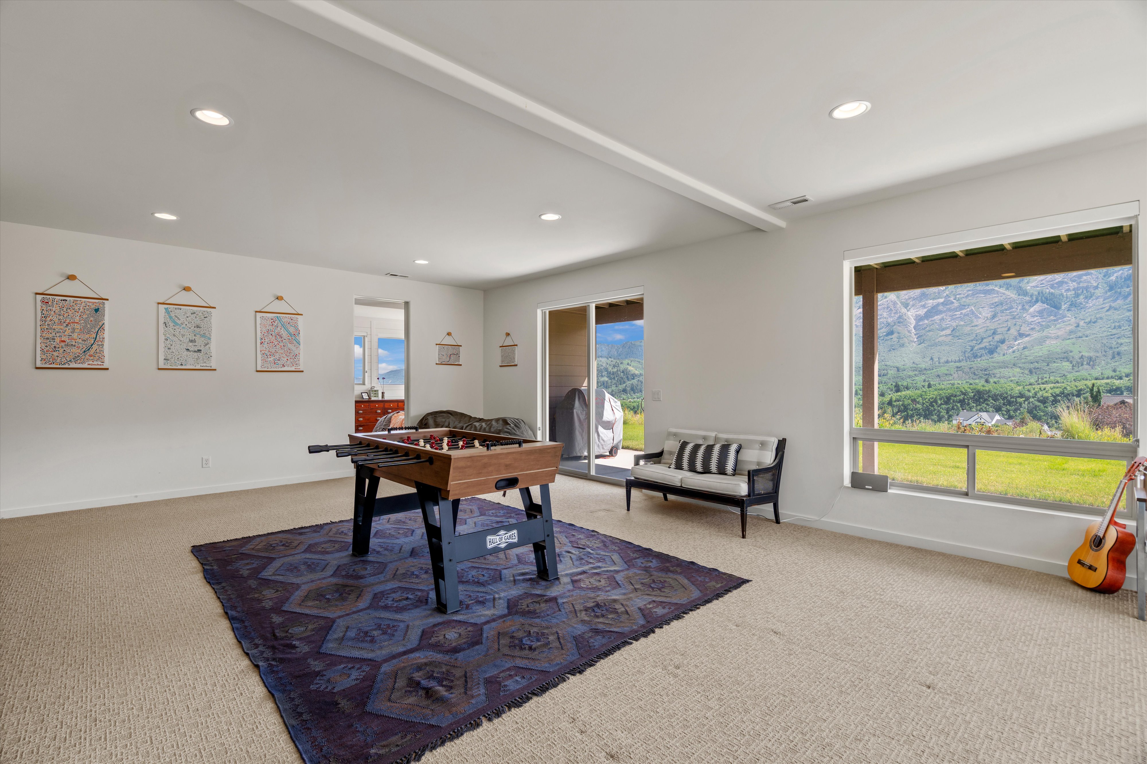 Expansive recreation room featuring recessed lighting, a sliding glass door, and a large window presenting mountainous scenery