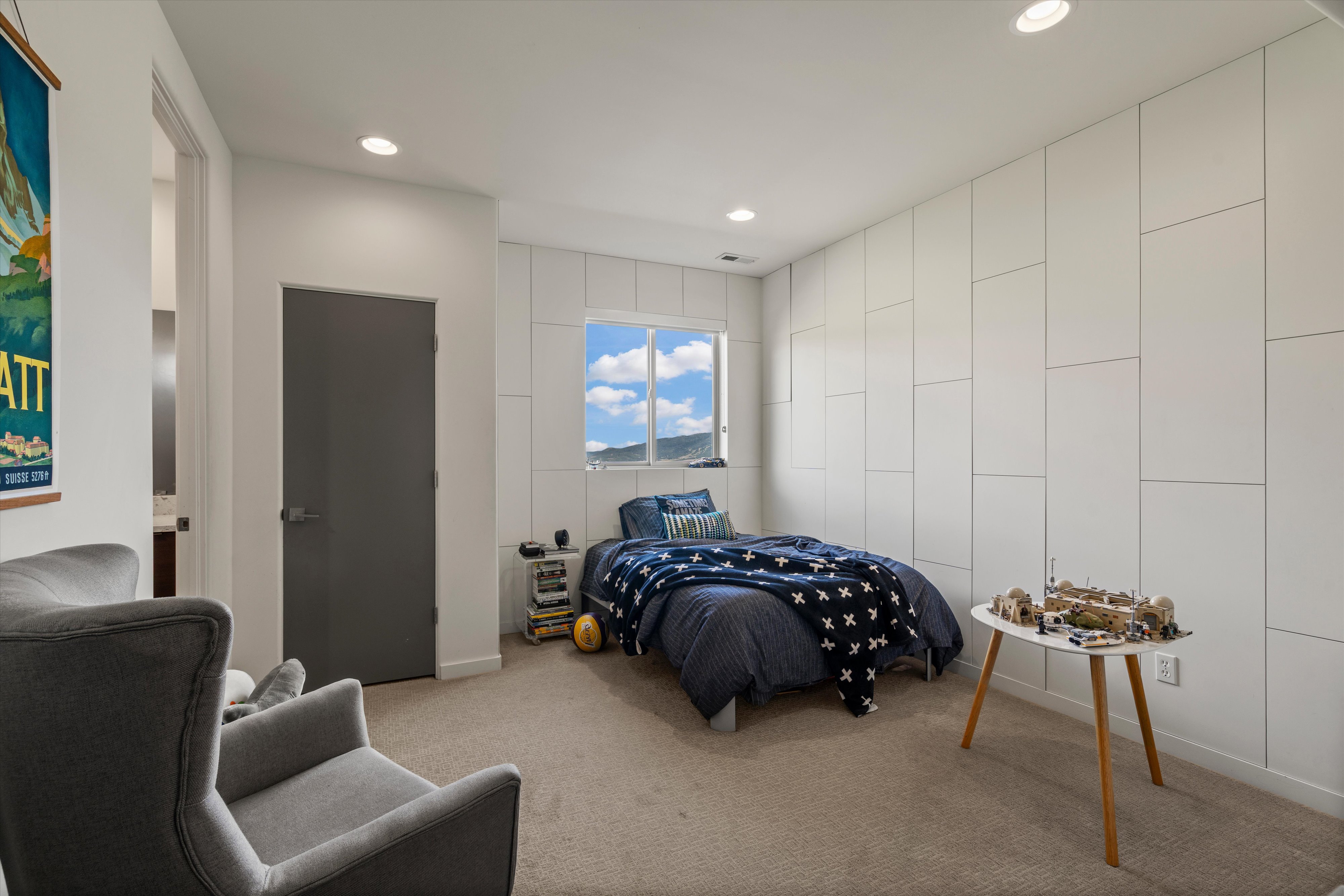 Recessed lighting illuminates a space featuring a prominent window with mountain scenery