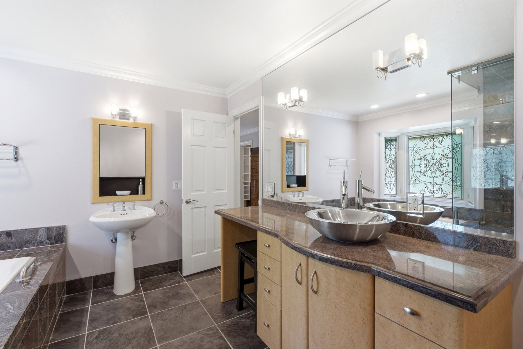 Double vanity featuring a stainless steel vessel sink, wood-finish cabinetry, and a full-length mirror