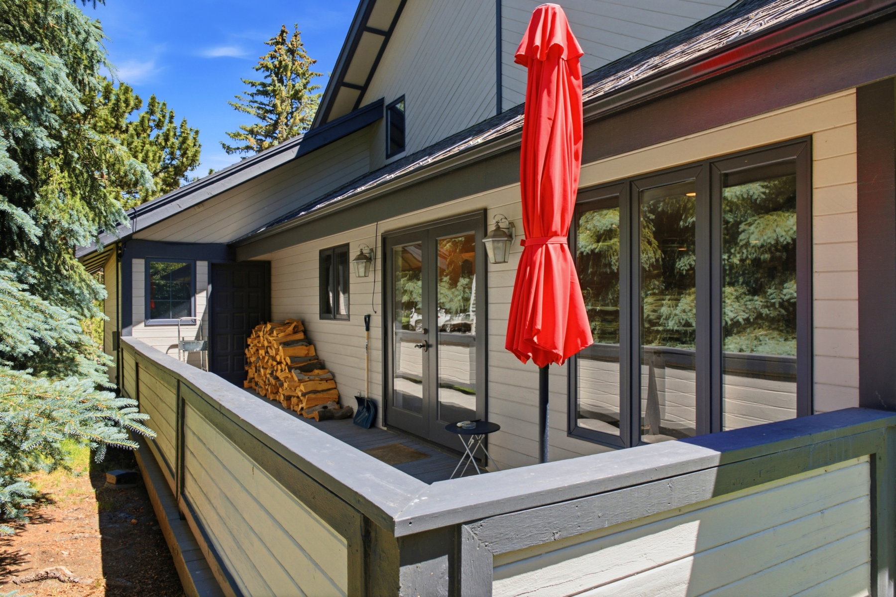 Exterior deck featuring wood-finish railing, composite decking, and multiple glass-paned doors