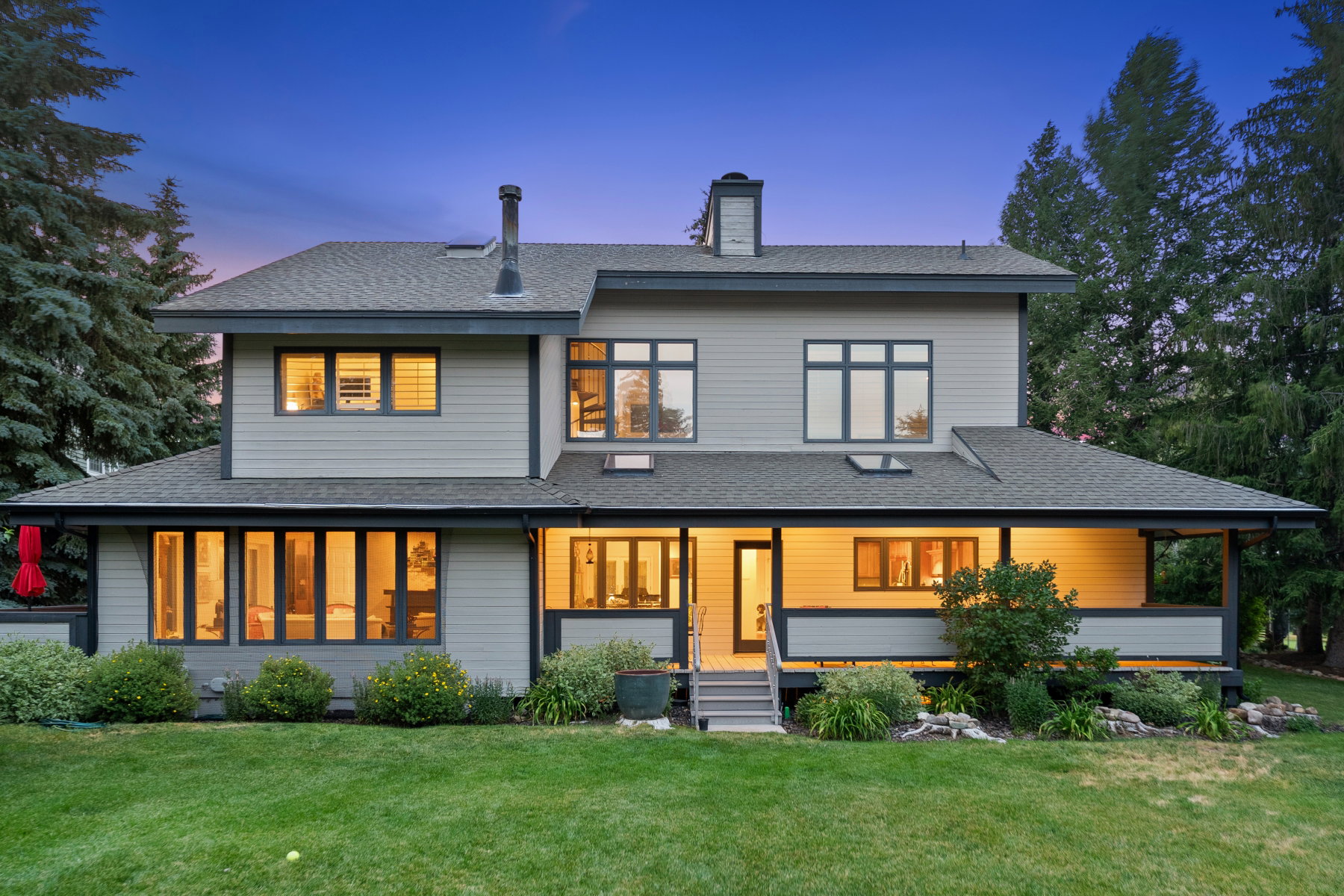 Contemporary two-story residence with light gray siding and dark trim