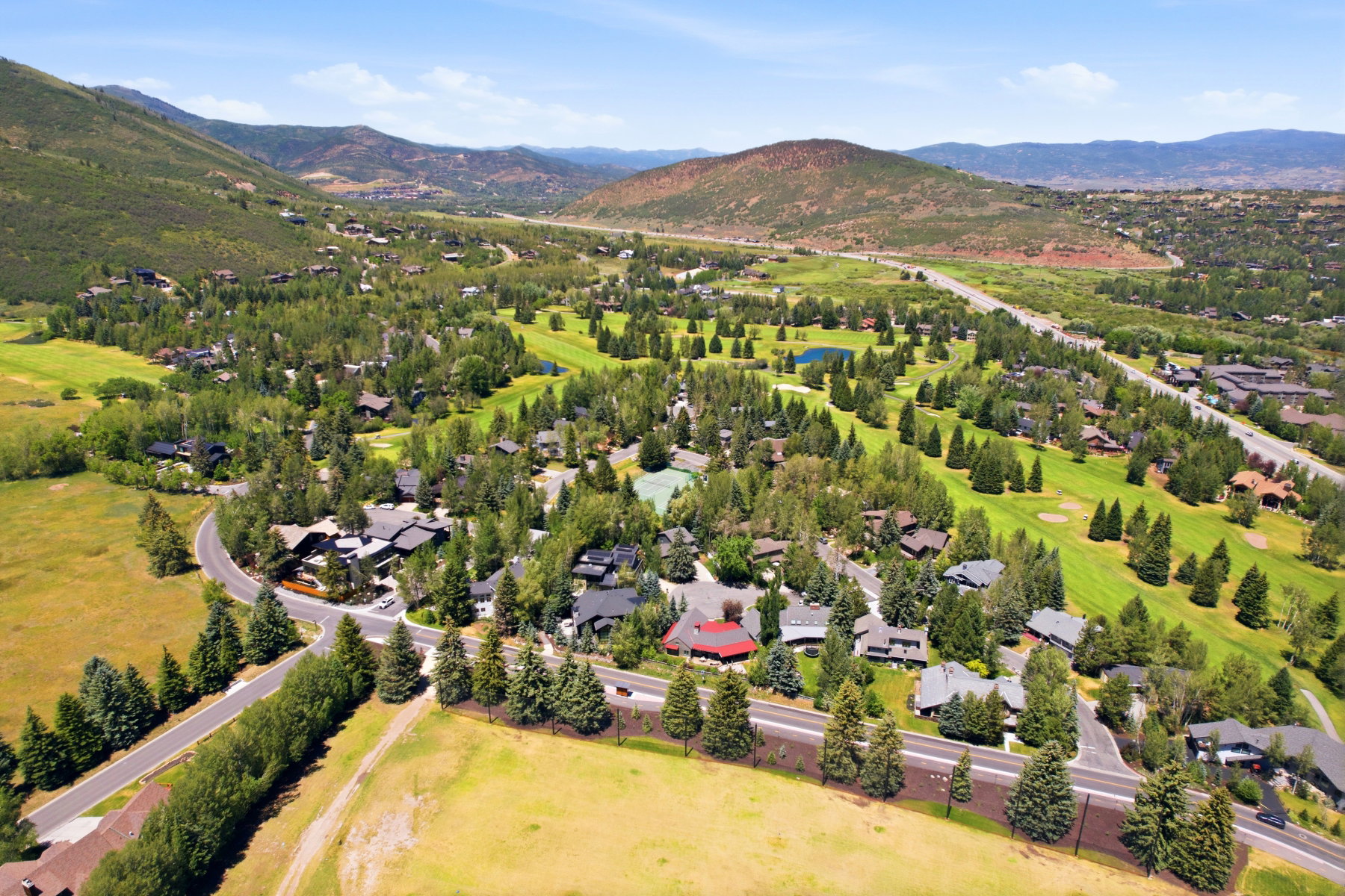 Aerial perspective showcasing a residential community amidst lush green landscapes and distant mountains