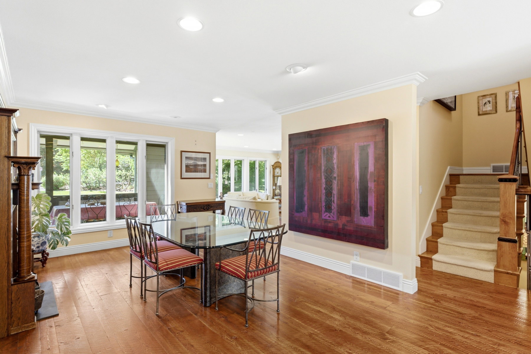 Open-concept living area featuring rich wood-finish flooring, recessed lighting, and expansive windows