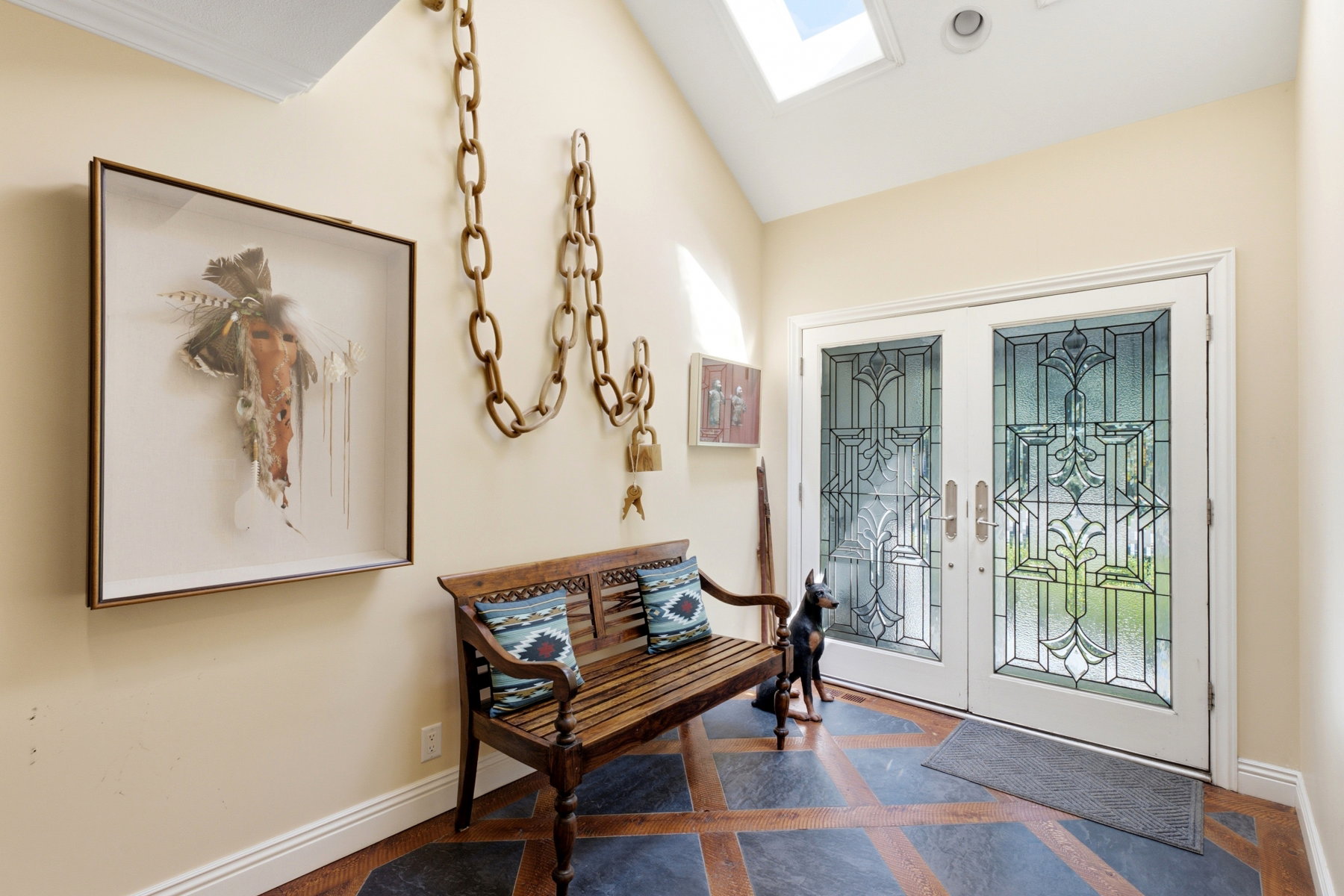 Vaulted entryway featuring a skylight, recessed lighting, and leaded glass double doors