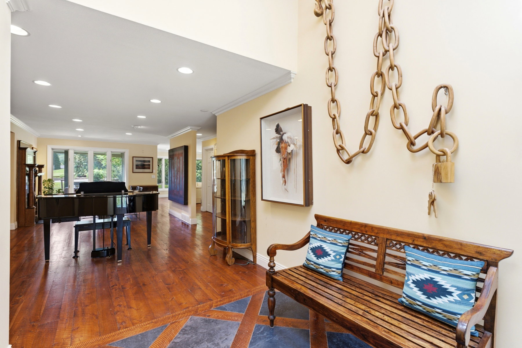 Hardwood flooring with stone inlay at the entry, recessed lighting, and crown molding