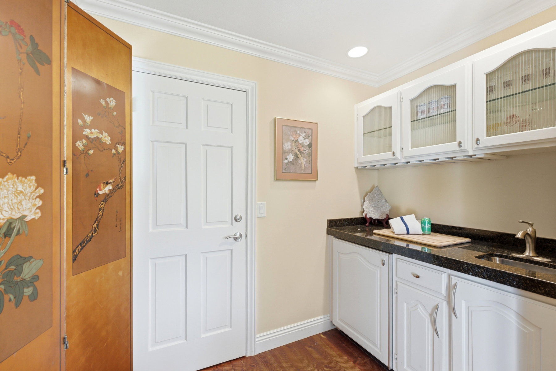 White cabinetry featuring frosted glass inserts and under-cabinet glass racks