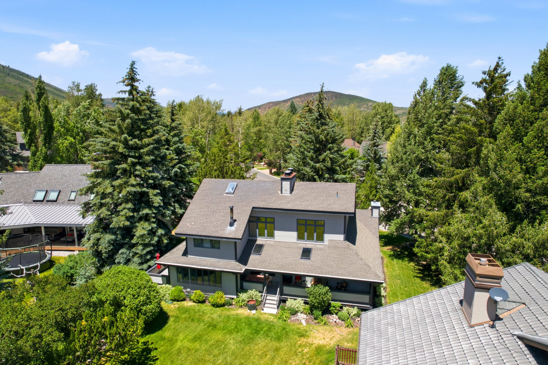 Modern residence featuring a multi-level roofline, skylights, and a covered front porch