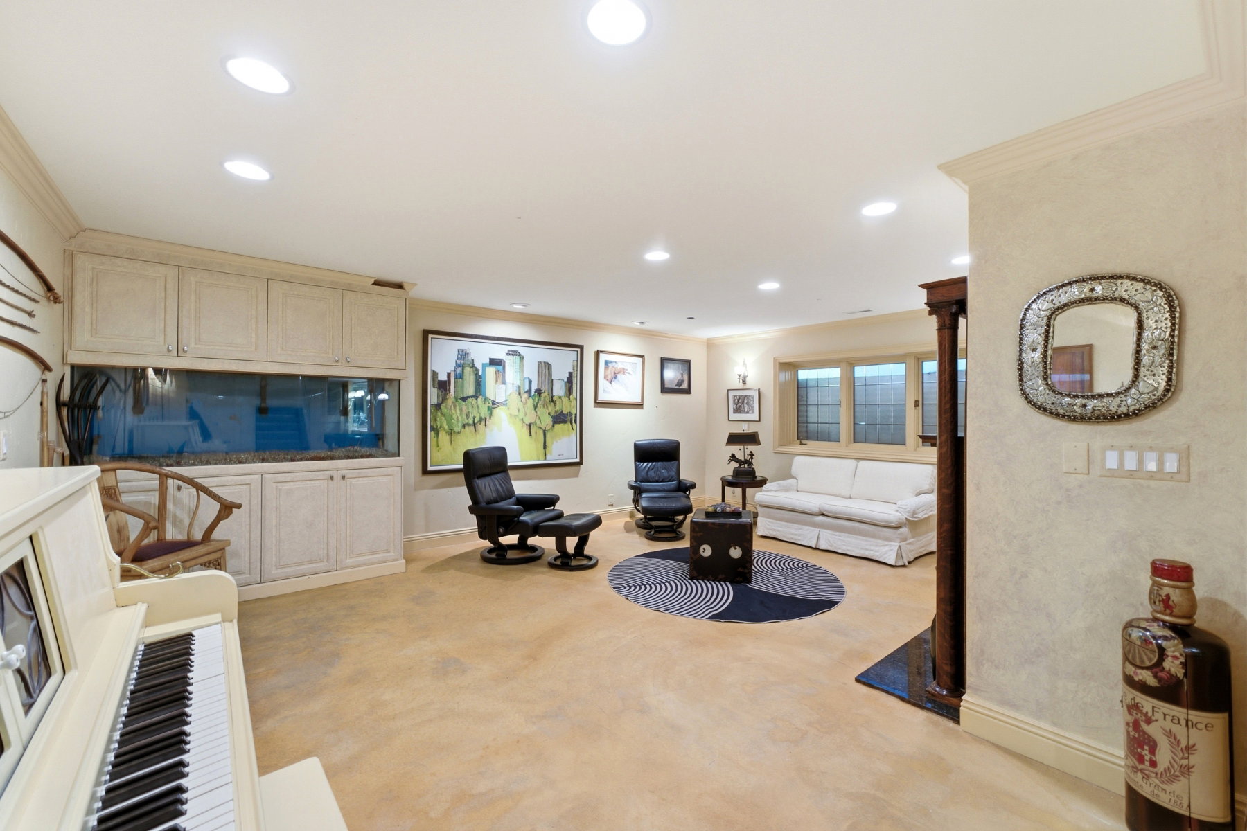 Spacious room featuring recessed lighting, a built-in aquarium with cabinetry, and light-toned flooring