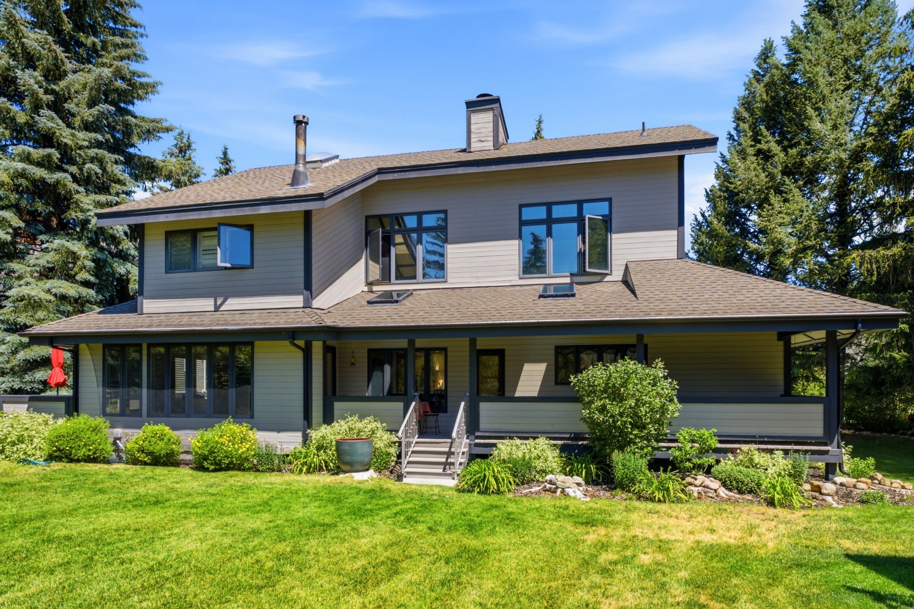 Contemporary architecture featuring a multi-level design with light-toned siding and dark trim