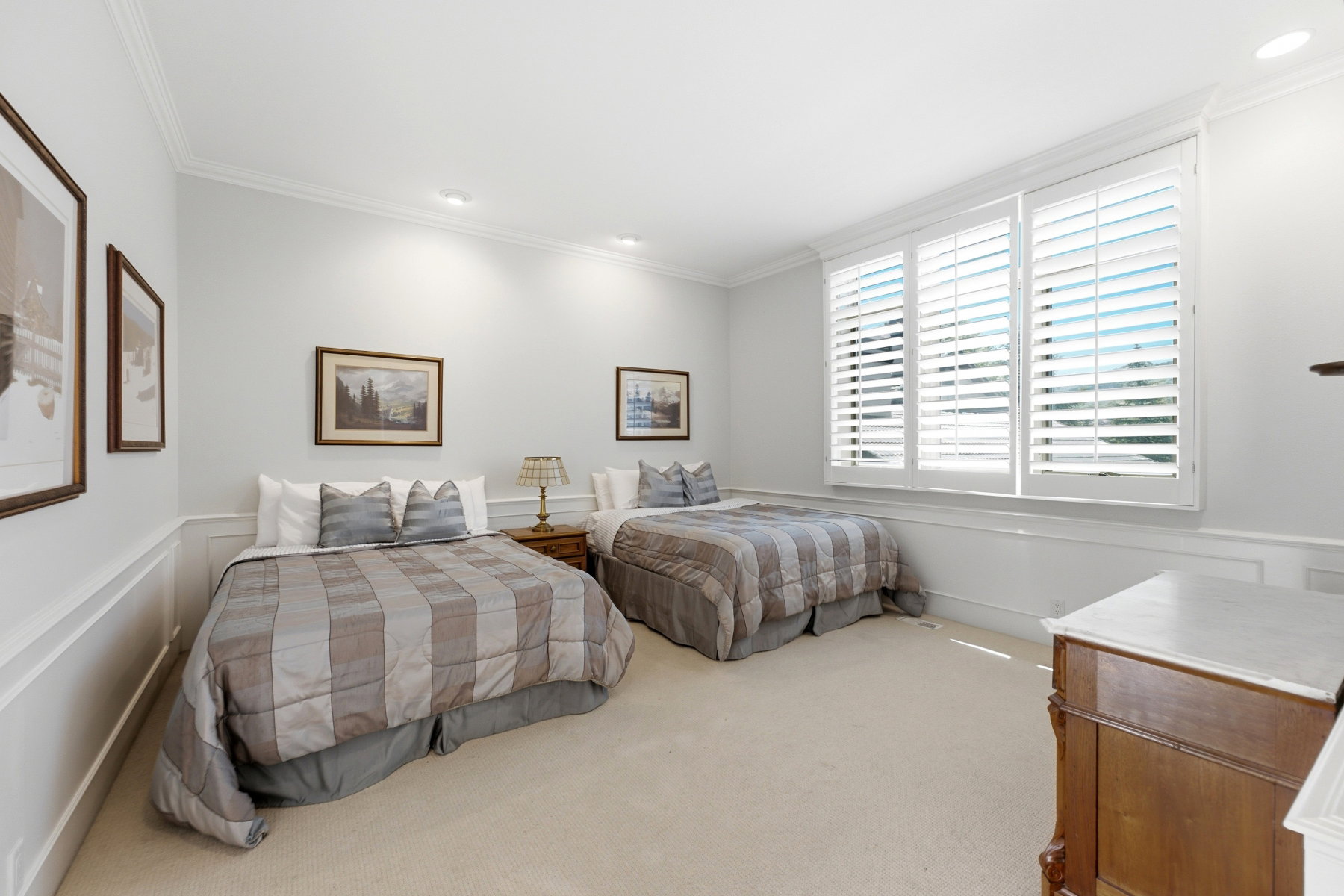 Room with expansive window featuring white plantation shutters