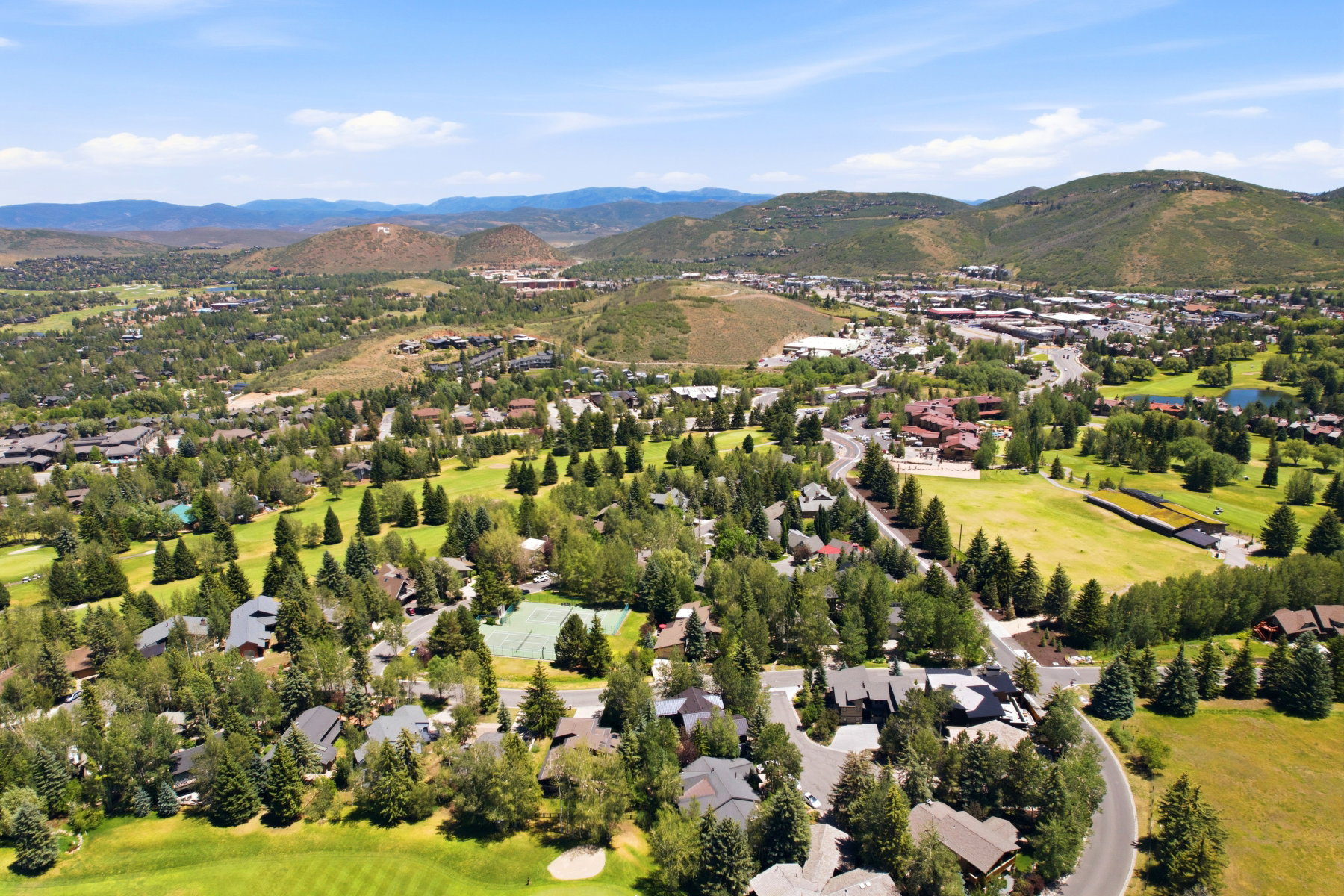 Expansive aerial showcasing a verdant landscape with rolling hills and distant mountains