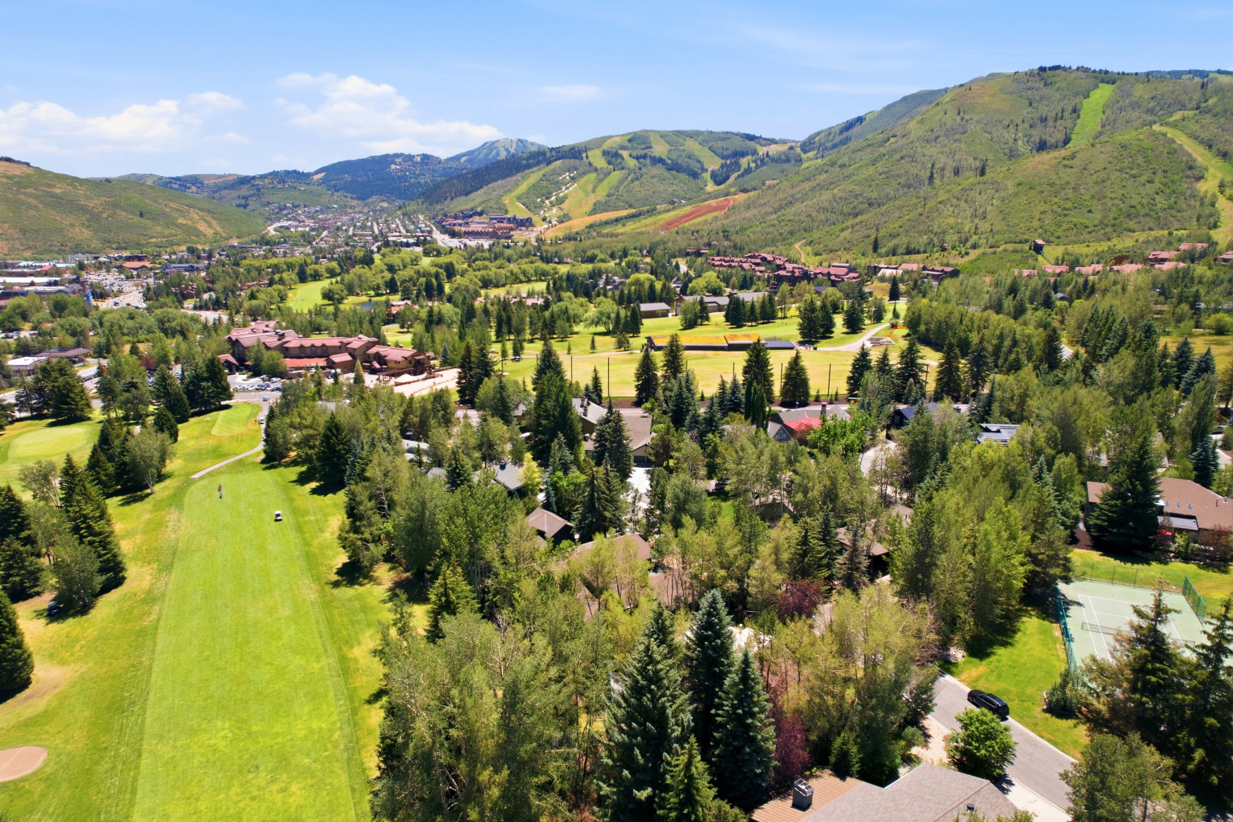 Expansive property with a golf course frontage, mature tree coverage, and mountain scenery