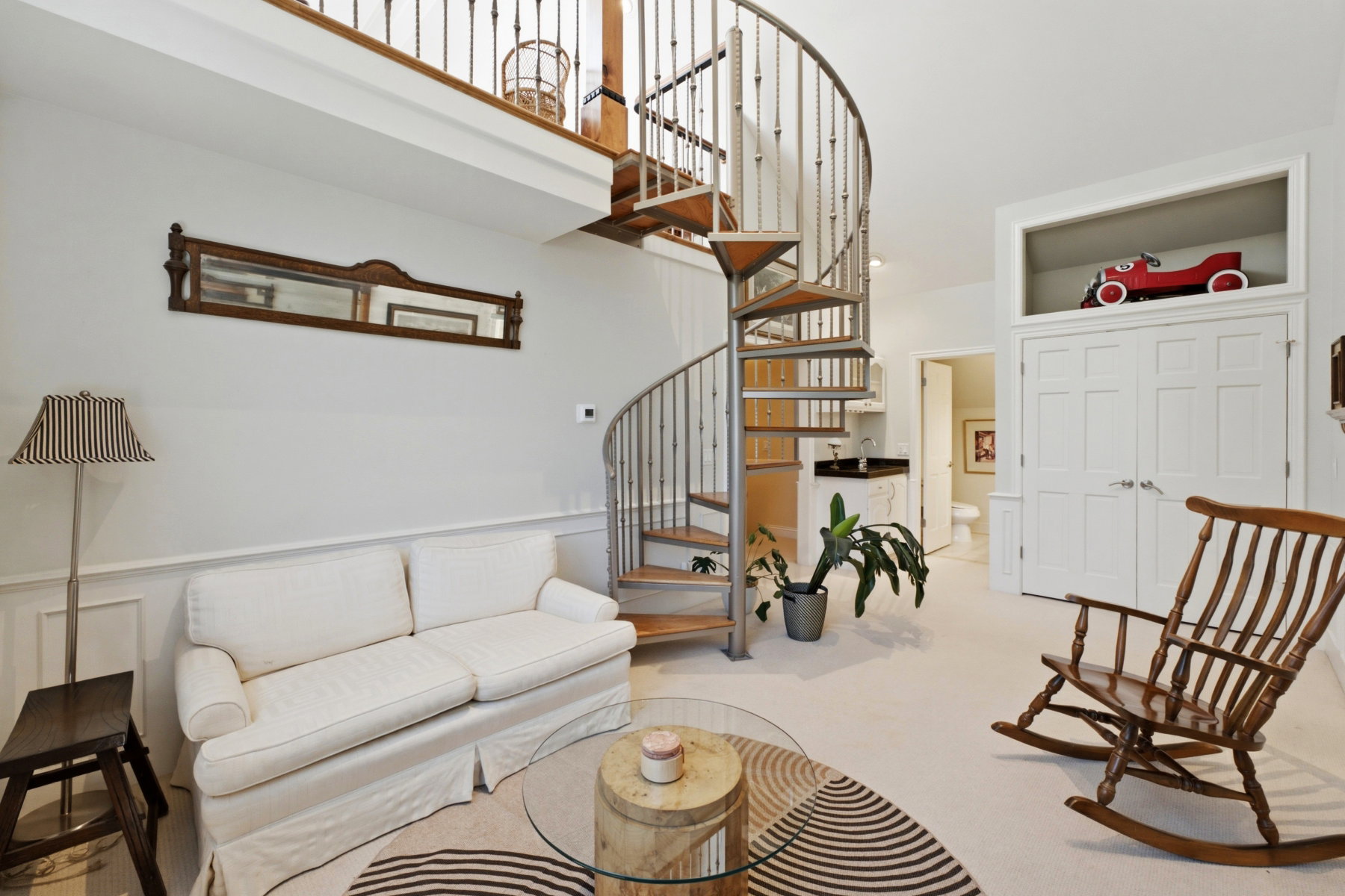 Spiral staircase with wrought iron balusters and wood-finish treads