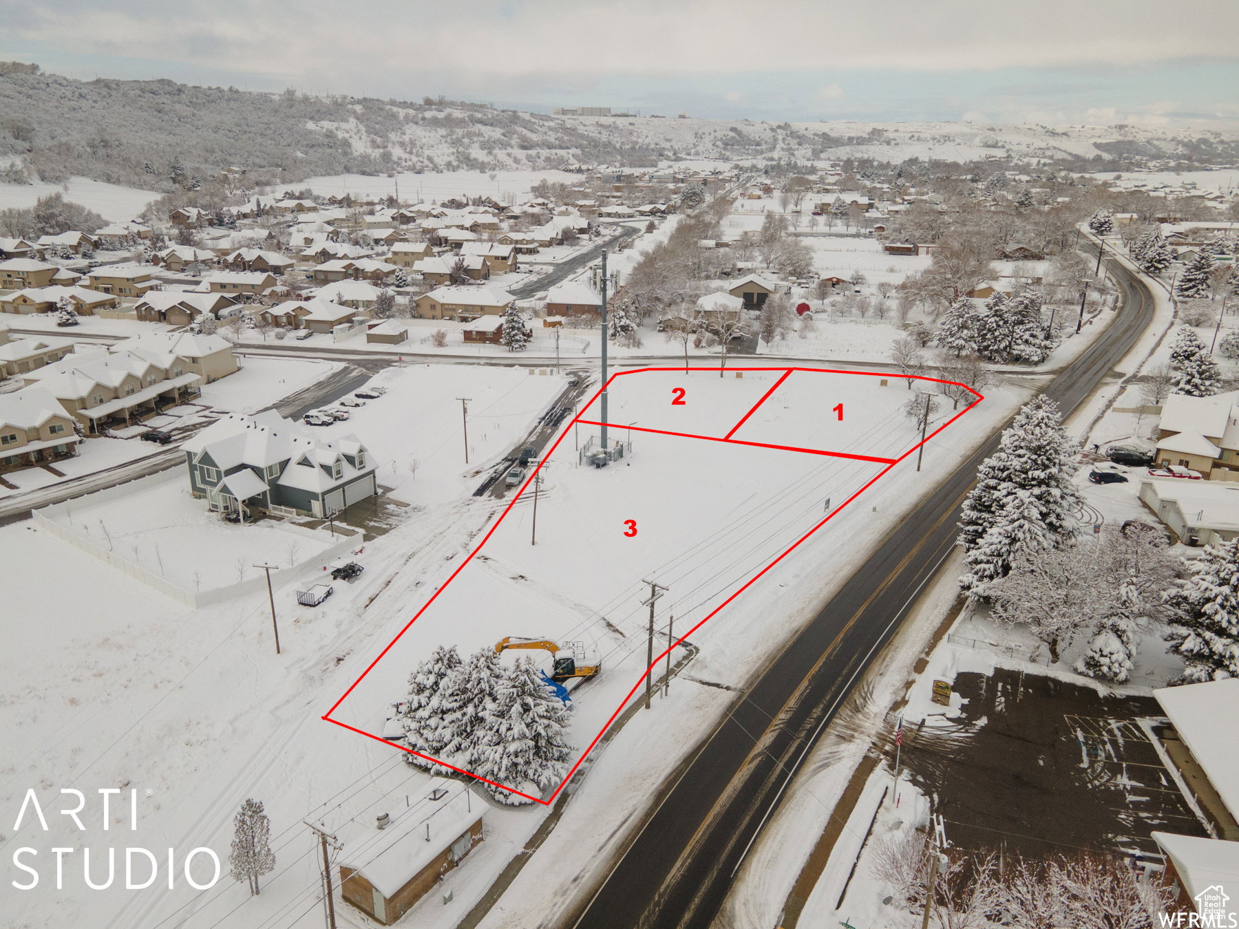 Expansive land parcel featuring clear demarcation, road frontage, utility poles, and surrounding residential structures