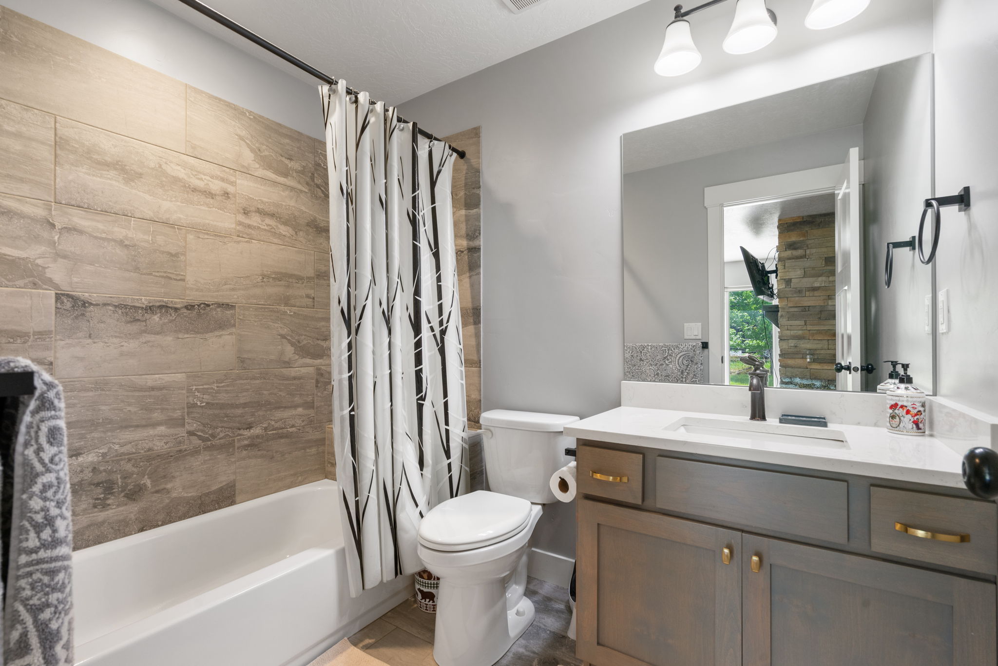 Bathroom featuring a white tub with floor-to-ceiling textured tile surround