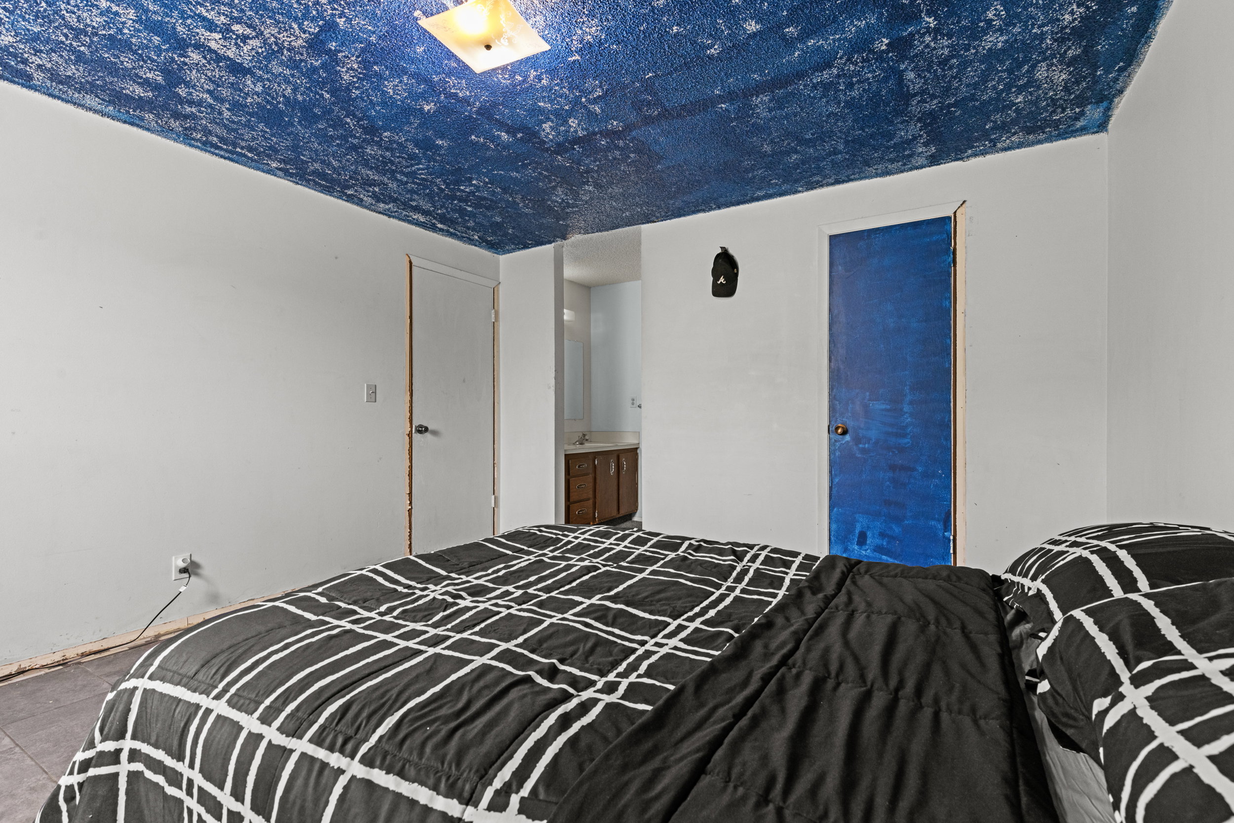 Room featuring white walls and a distinct blue ceiling