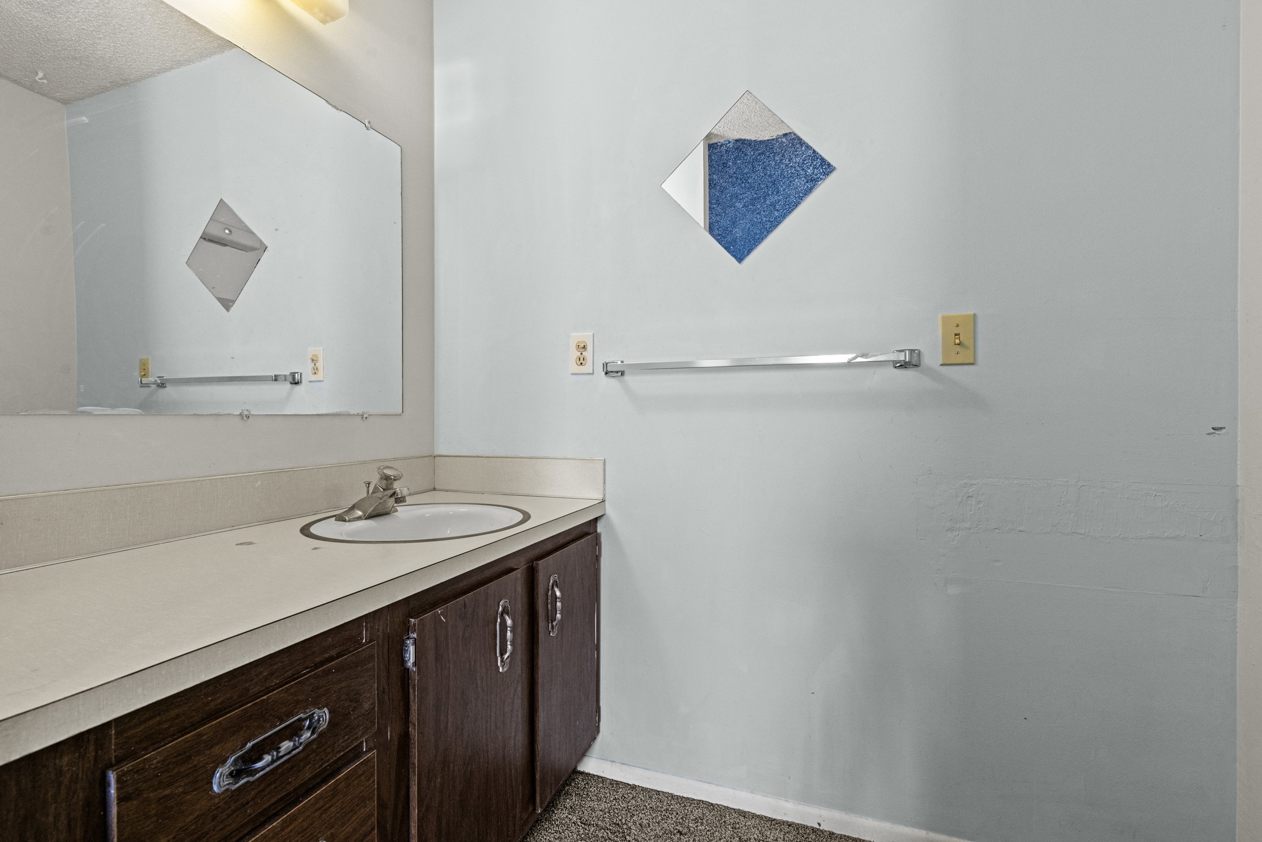 Bathroom vanity with an integrated sink, wood-finish cabinetry, and a chrome faucet