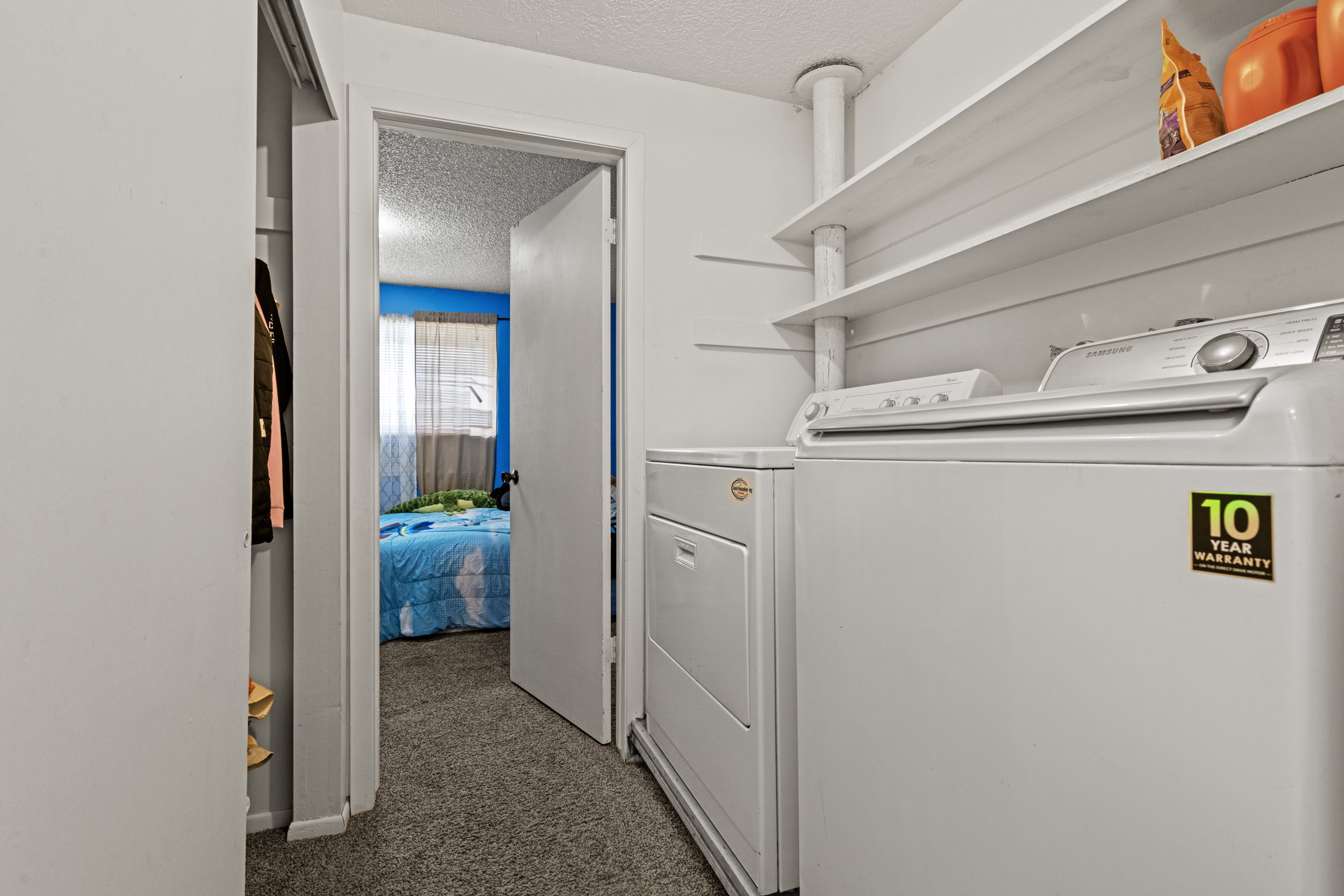 Dedicated laundry area featuring a white washing machine, white dryer, and two wall-mounted storage shelves