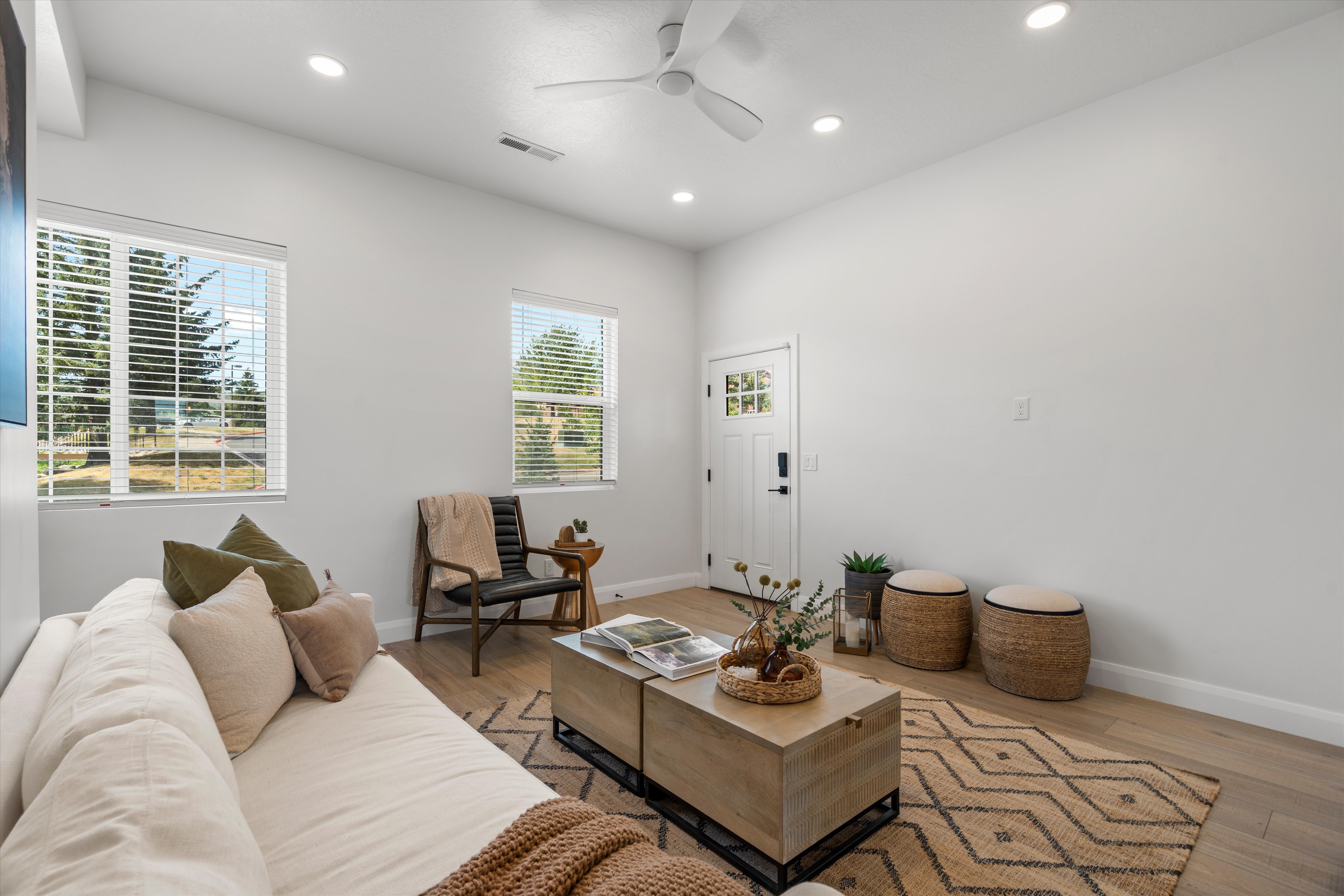 Open-concept living space featuring wood-finish flooring, recessed lighting, and a modern ceiling fan