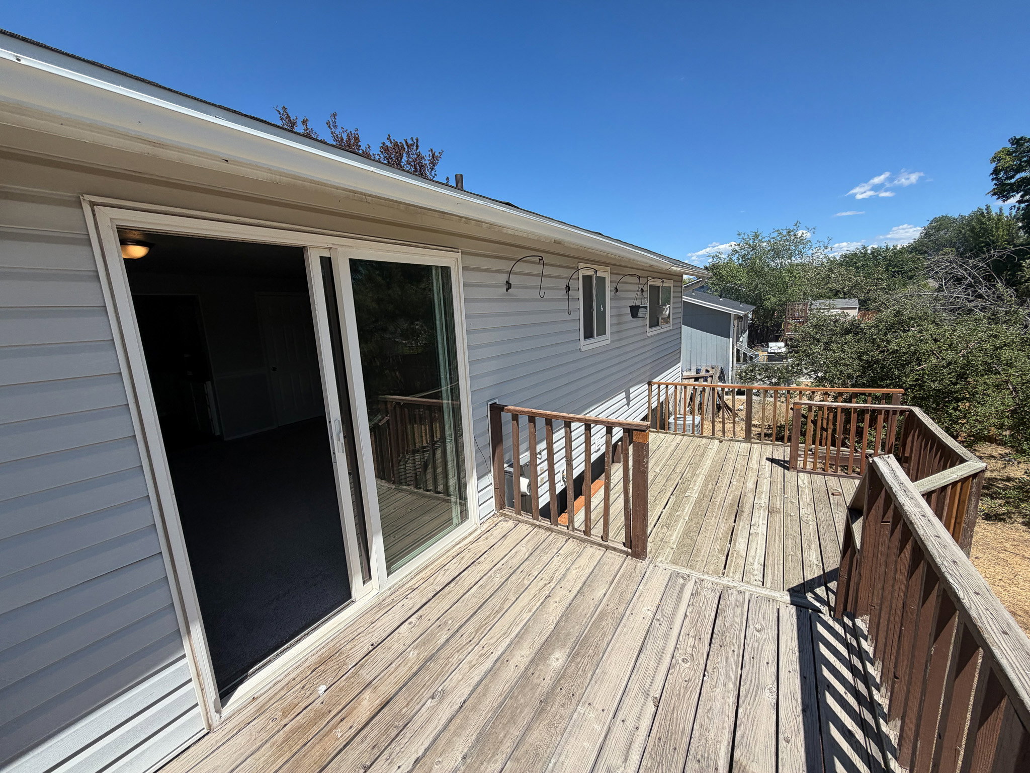 Expansive wood deck with wood railings, providing outdoor living space