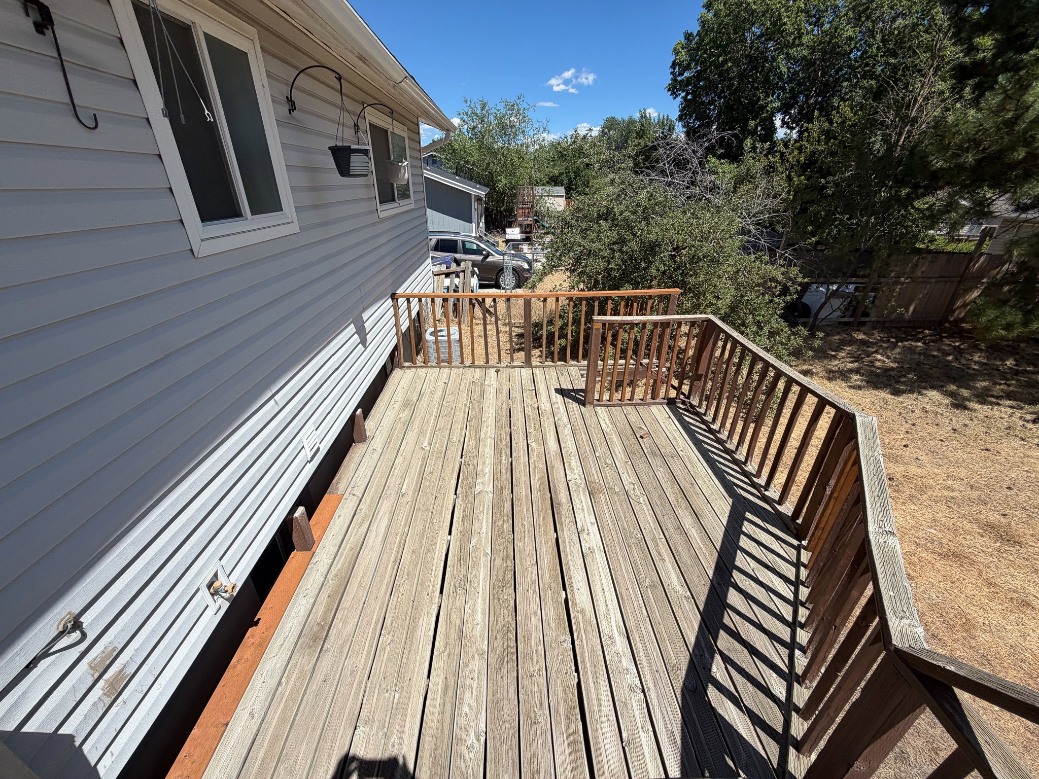 Spacious outdoor deck with natural wood planks and railing
