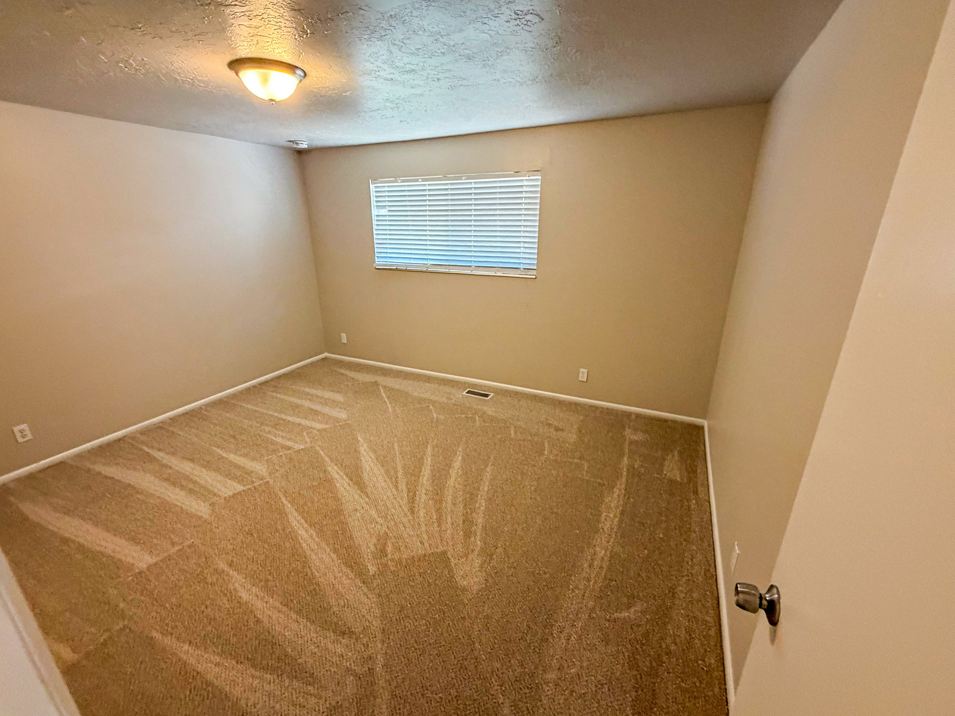 Neutral tone wall paint with a window featuring horizontal blinds