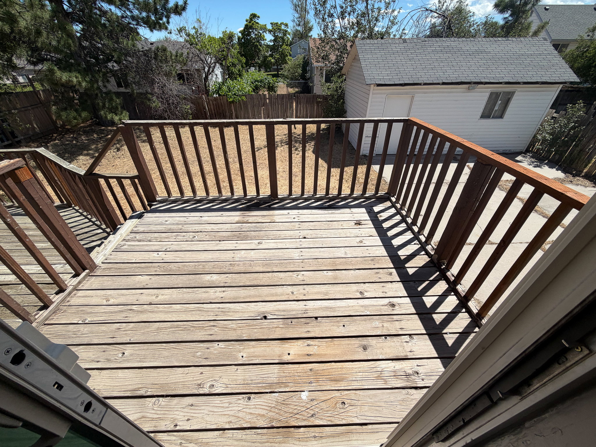Spacious outdoor deck with natural wood planks and a coordinating wood railing