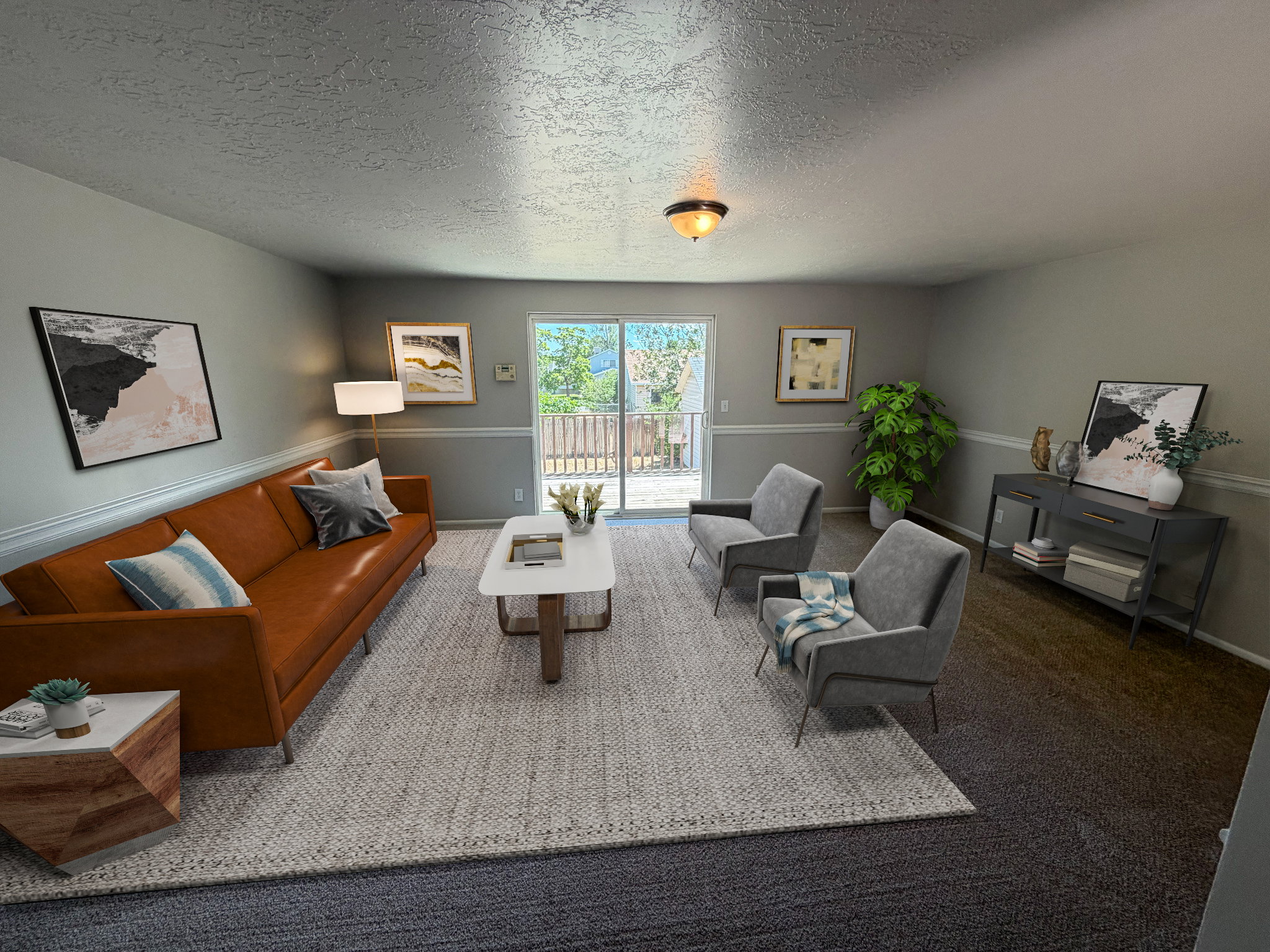 Living area featuring light gray walls with chair rail molding, dark carpet, and a sliding glass door providing outdoor access